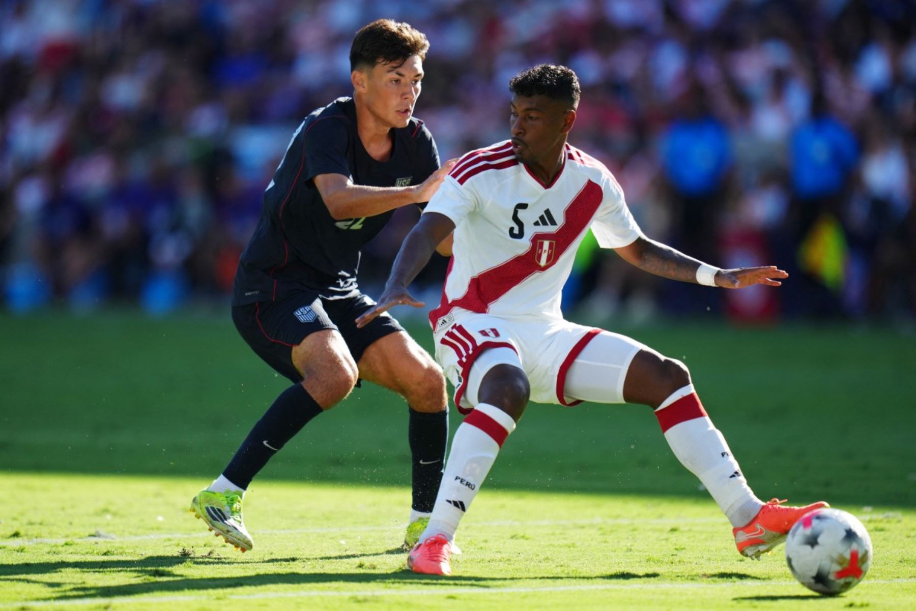 Miguel Araujo #5 de Perú controla el balón bajo la presión de Justin Ellis #22 de Estados Unidos durante el partido amistoso internacional entre Estados Unidos y Perú en el Estadio Inter.co el 26 de septiembre de 2026 en Orlando, Florida. Foto: AFP