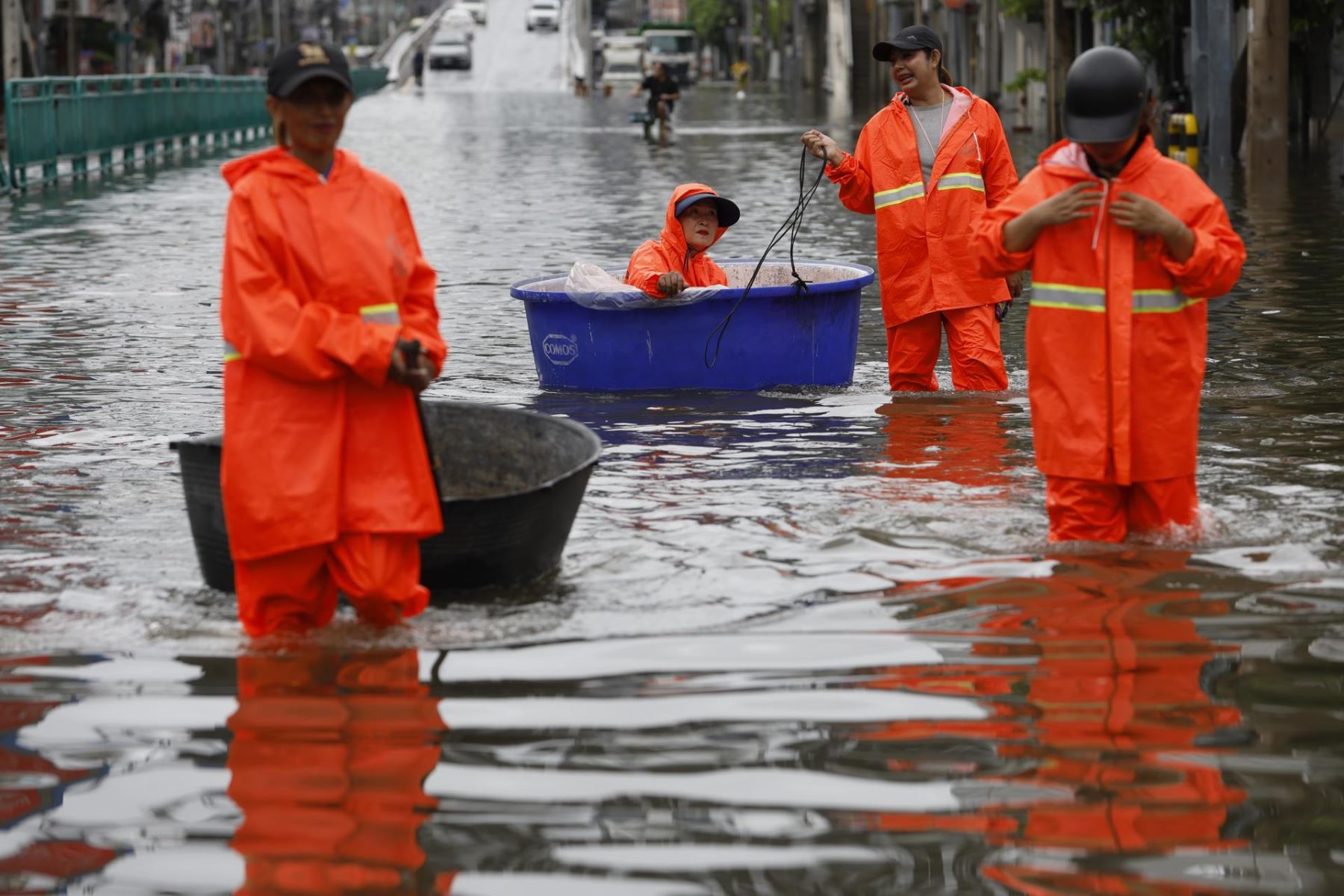 Un trabajador municipal de Bangkok se sienta en un recipiente de plástico y es arrastrado por un compañero mientras recogen escombros tras un aguacero prolongado en una calle principal inundada, la carretera Phetchaburi, en Bangkok.
Foto: EFE