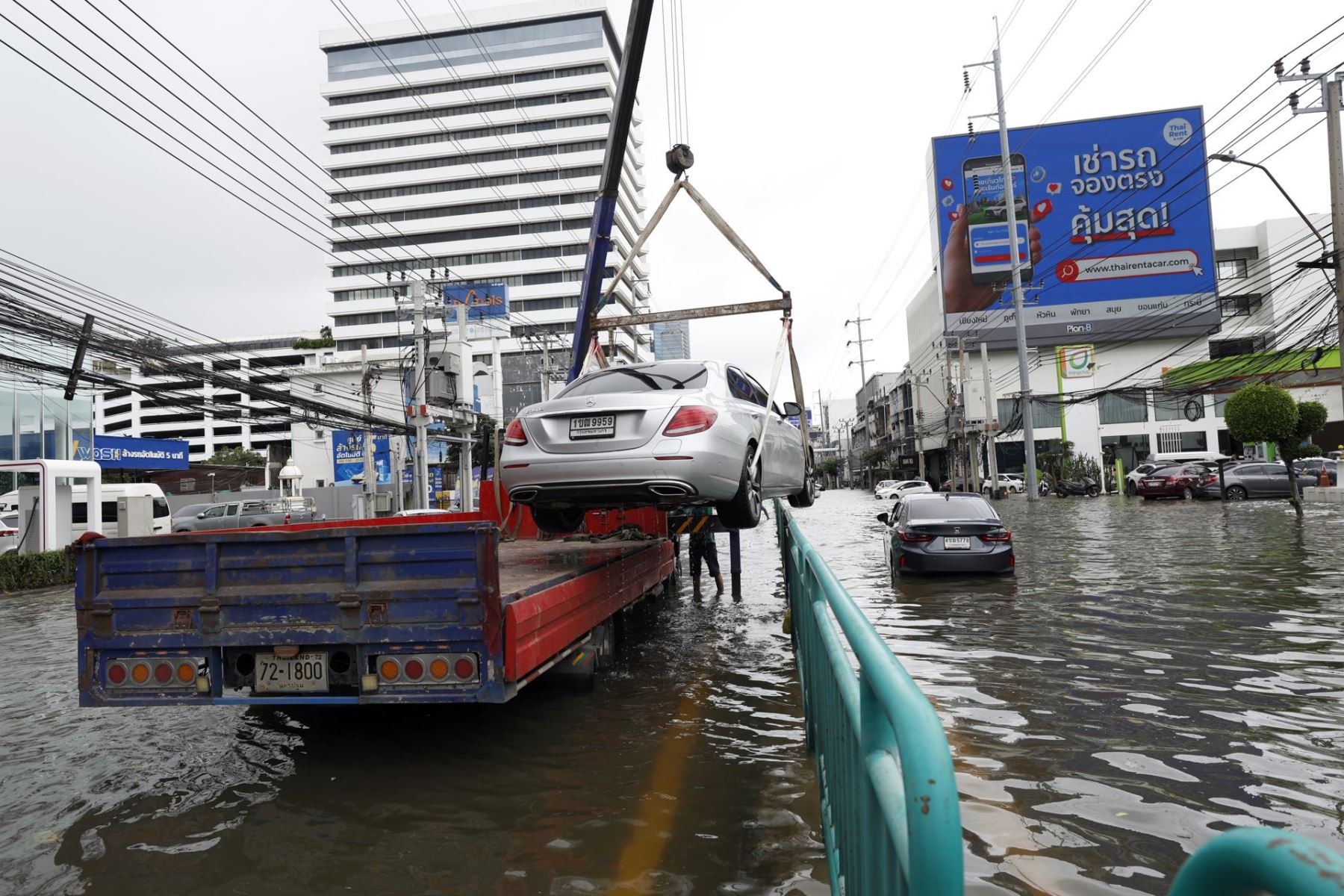 Un operario de un servicio de grúa retira un automóvil averiado tras un aguacero prolongado en una importante calle inundada, la carretera Phetchaburi, en Bangkok (Tailandia)
Foto: EFE