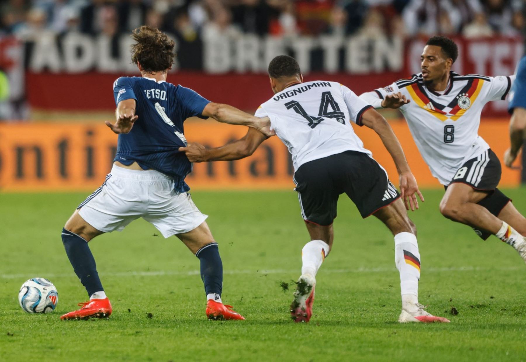 El defensa griego Panagiotis Retsos (n.º 5) y el defensa alemán Josha Vagnoman (n.º 14) disputan el balón durante el partido de la fase de grupos A2 de la Liga de Naciones de la UEFA entre Alemania y Grecia en Augsburgo, al sur de Alemania, el 27 de septiembre de 2026. (Foto de Michaela STACHE / AFP)