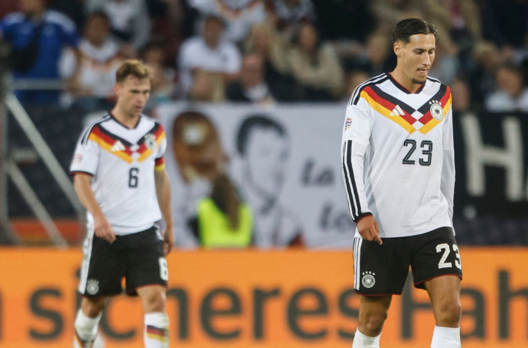 El centrocampista alemán Joshua Kimmich (izq.), número 6 del ranking, y el delantero alemán Younes Ebnoutalib, número 23, reaccionan tras un gol de Grecia durante el partido de la fase de grupos A2 de la Liga de Naciones de la UEFA entre Alemania y Grecia en Augsburgo, al sur de Alemania, el 27 de septiembre de 2026. (Foto de Michaela STACHE / AFP)