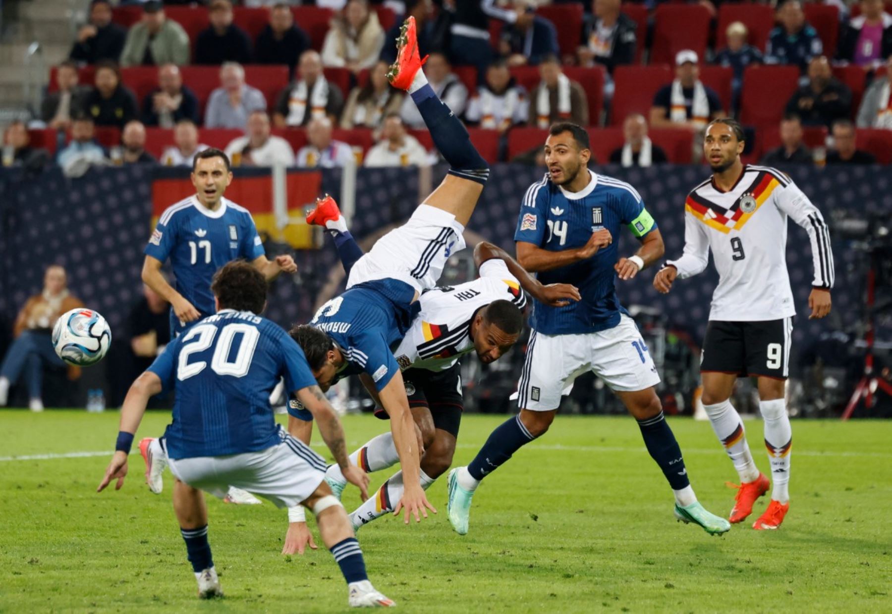 El defensa griego Ntinos Mavropanos, con el número 4, es placado por el defensa alemán Jonathan Tah, también con el número 4, durante el partido de la fase de grupos A2 de la Liga de Naciones de la UEFA entre Alemania y Grecia en Augsburgo, al sur de Alemania, el 27 de septiembre de 2026. (Foto de Michaela STACHE / AFP)