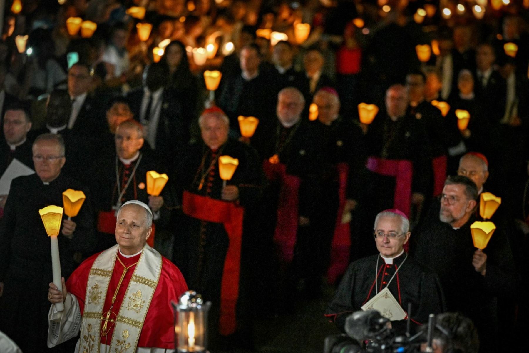 El papa León XIV (izq.) participa en una procesión con antorchas tras el rezo del Rosario en el Santuario de Nuestra Señora de Lourdes, en el suroeste de Francia, el 27 de septiembre de 2026, tercer día de su visita a Francia. (Foto de Lionel Bonaventure / AFP)
