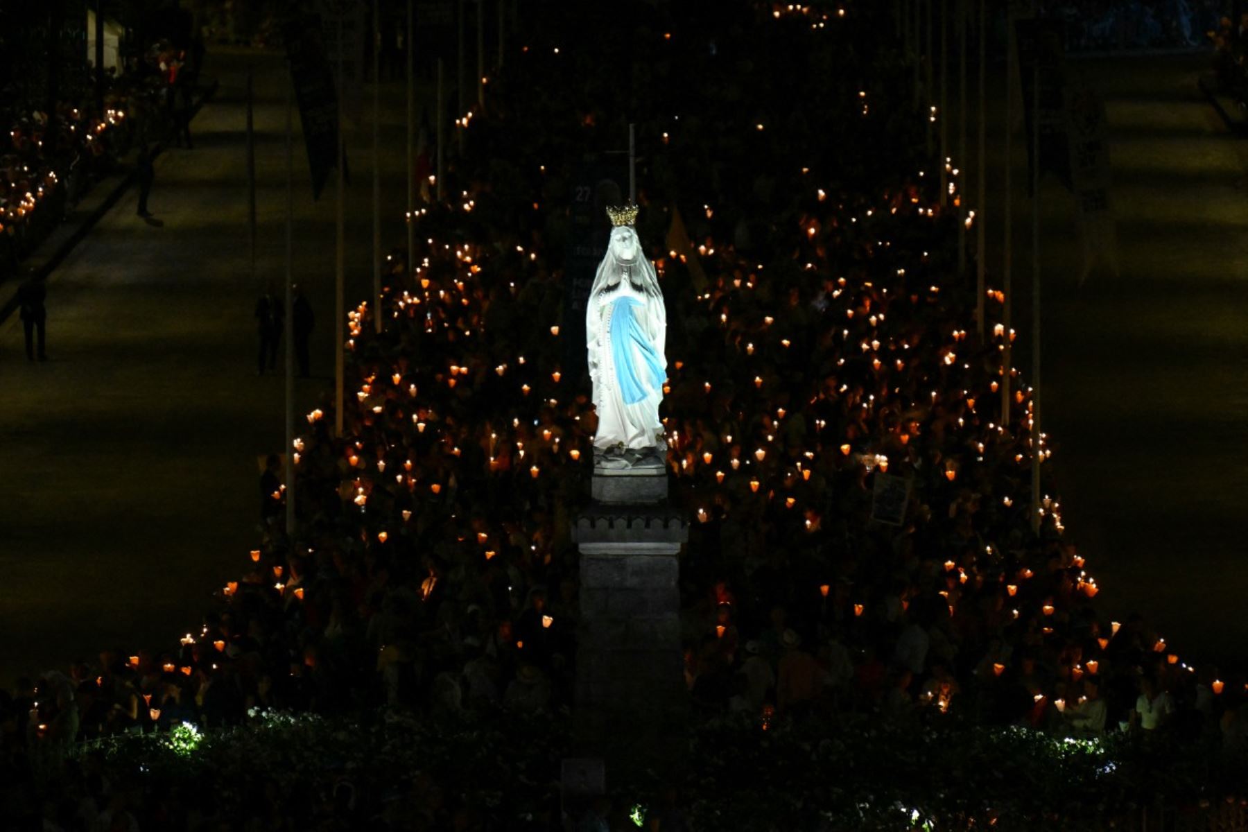 Fieles sostienen velas alrededor de una estatua de la Virgen María cerca de la Basílica del Santo Rosario antes de un rosario y una procesión con antorchas con el Papa León XIV en Lourdes, al suroeste de Francia, el 27 de septiembre de 2026, en el tercer día de su viaje a Francia. (Foto de Alberto PIZZOLI / AFP)