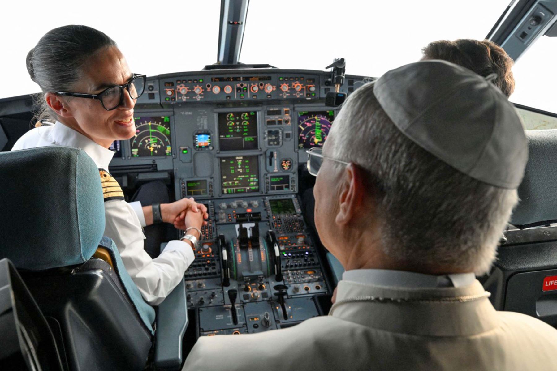 La piloto de Air France Clemence Coussonnea y su copiloto conversan con el papa León XIV en la cabina de su Airbus A320, antes de aterrizar en el aeropuerto de Metz-Nancy-Lorena en el último día de la visita del pontífice al país. Foto: AFP