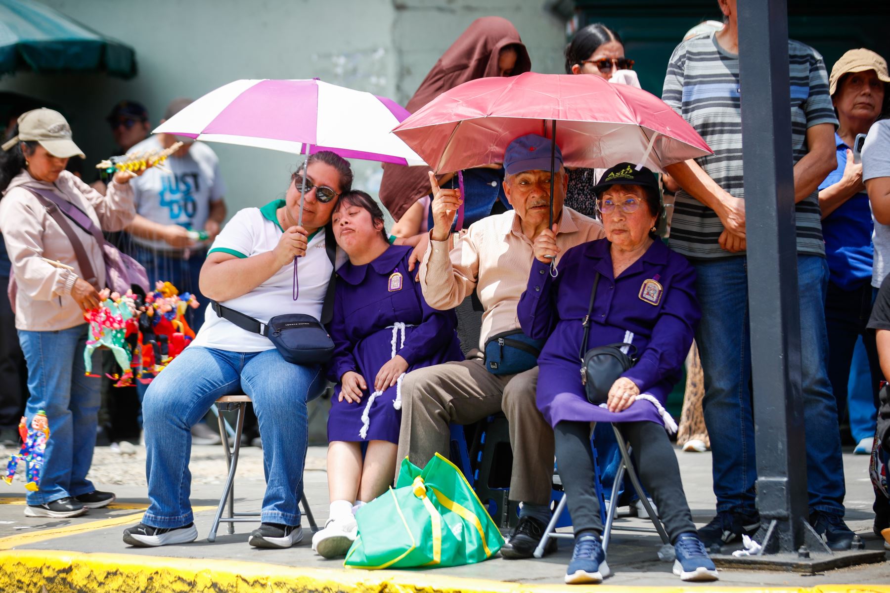 Fieles católicos sostienen velas encendidas y arreglos florales como símbolo de devoción y petición de milagros durante el recorrido religioso. Foto: ANDINA/Nombre del Fotógrafo