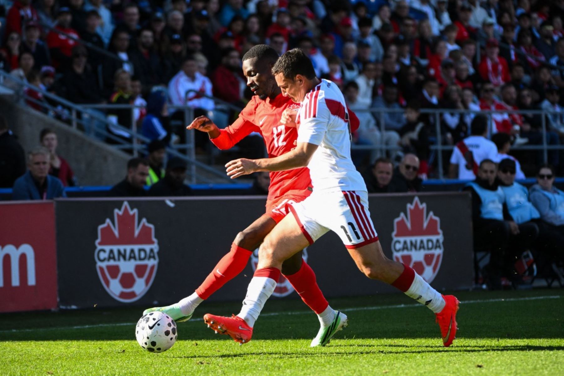 Tani Oluwaseyi de Canadá disputa el balón con Jairo Vélez de Perú durante la segunda parte de un partido amistoso internacional en el estadio Saputo,en Montreal (Canadá). AFP