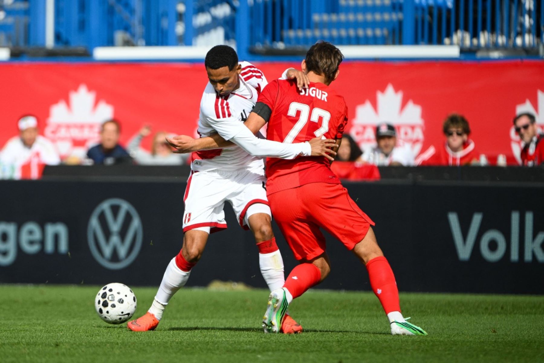 Niko Sigur  de Canadá disputa el balón con Marcos López  de Perú durante la primera parte de un partido amistoso internacional en el estadio Saputo, en Montreal (Canadá). AFP