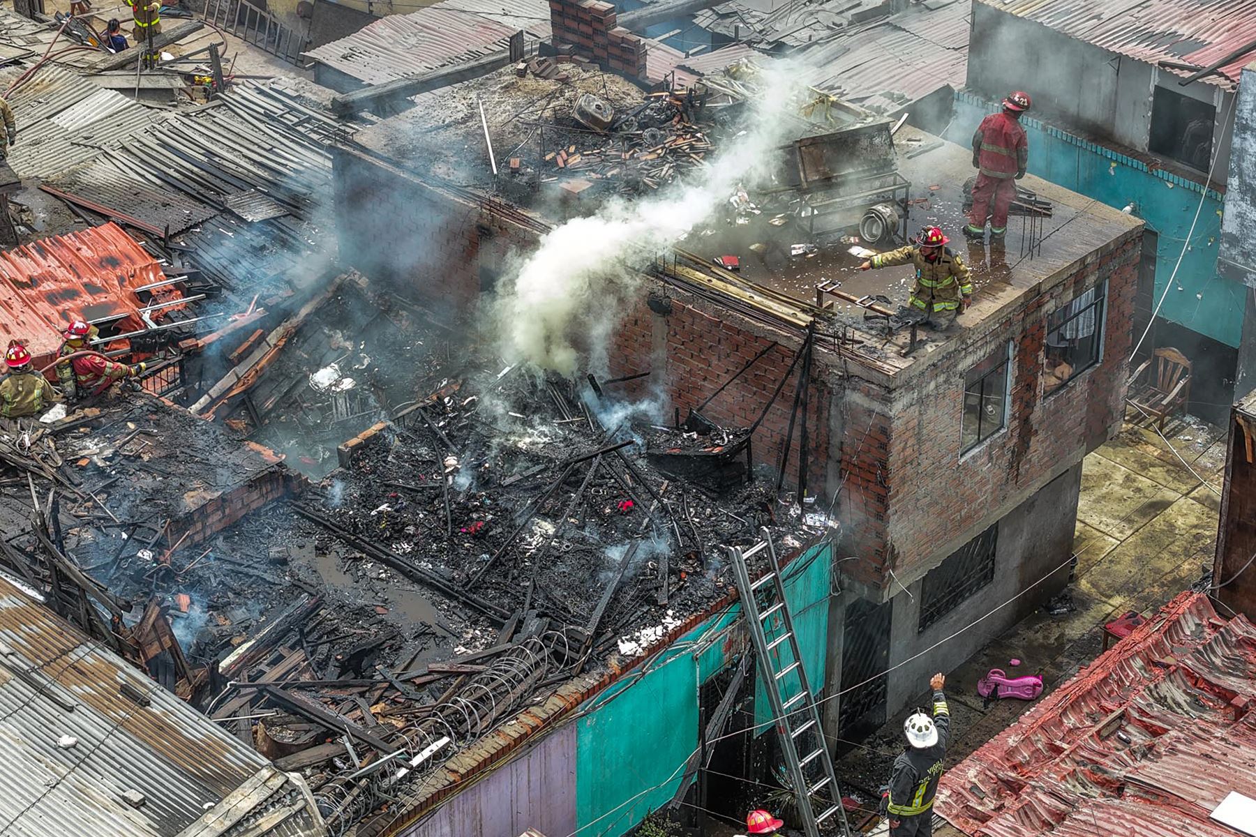 Bomberos controlan el incendio registrado en inmediaciones del cruce de los jirones Madera y Trujillo, en el Rímac. Foto: ANDINA/Daniel Bracamonte