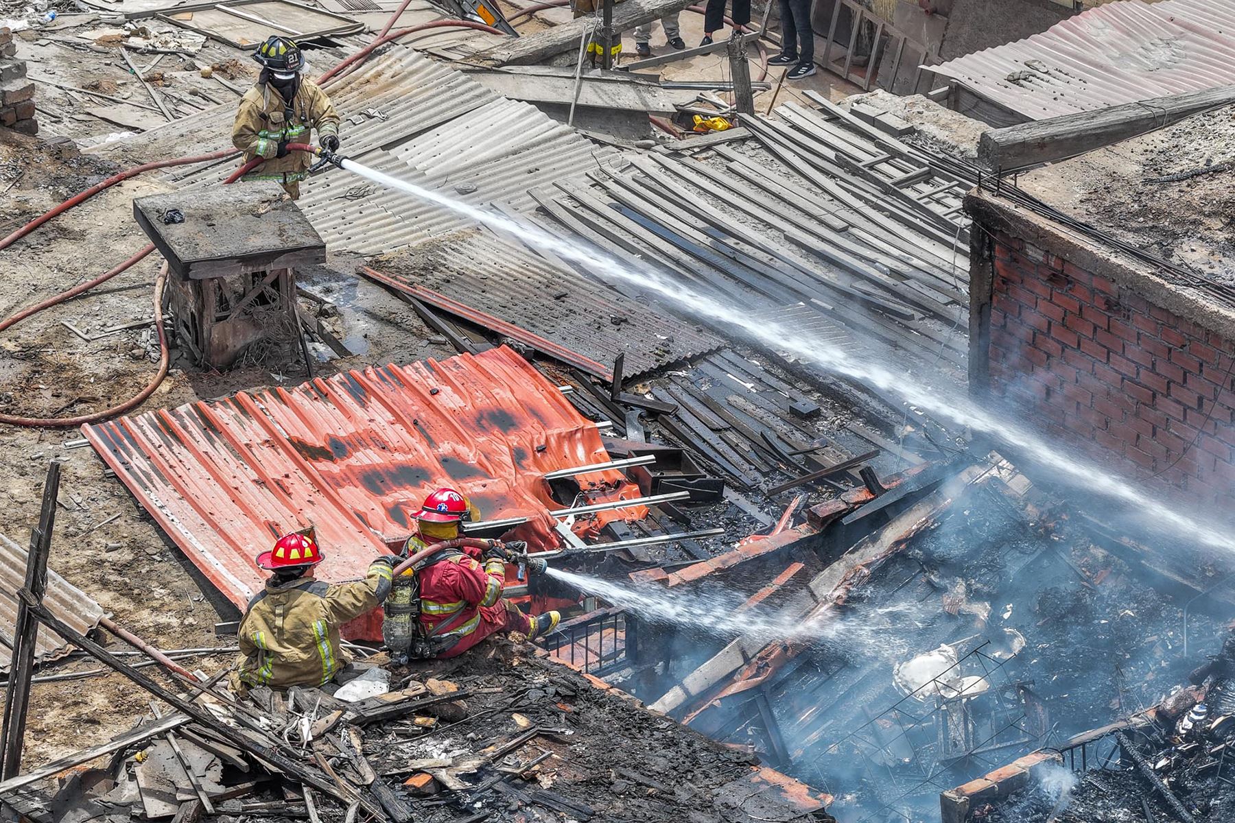 Bomberos trabajan en la zona donde se registró un incendio en el cruce de los jirones Madera y Trujillo, en el distrito del Rímac. La emergencia ya fue controlada. Foto: ANDINA/Daniel Bracamonte