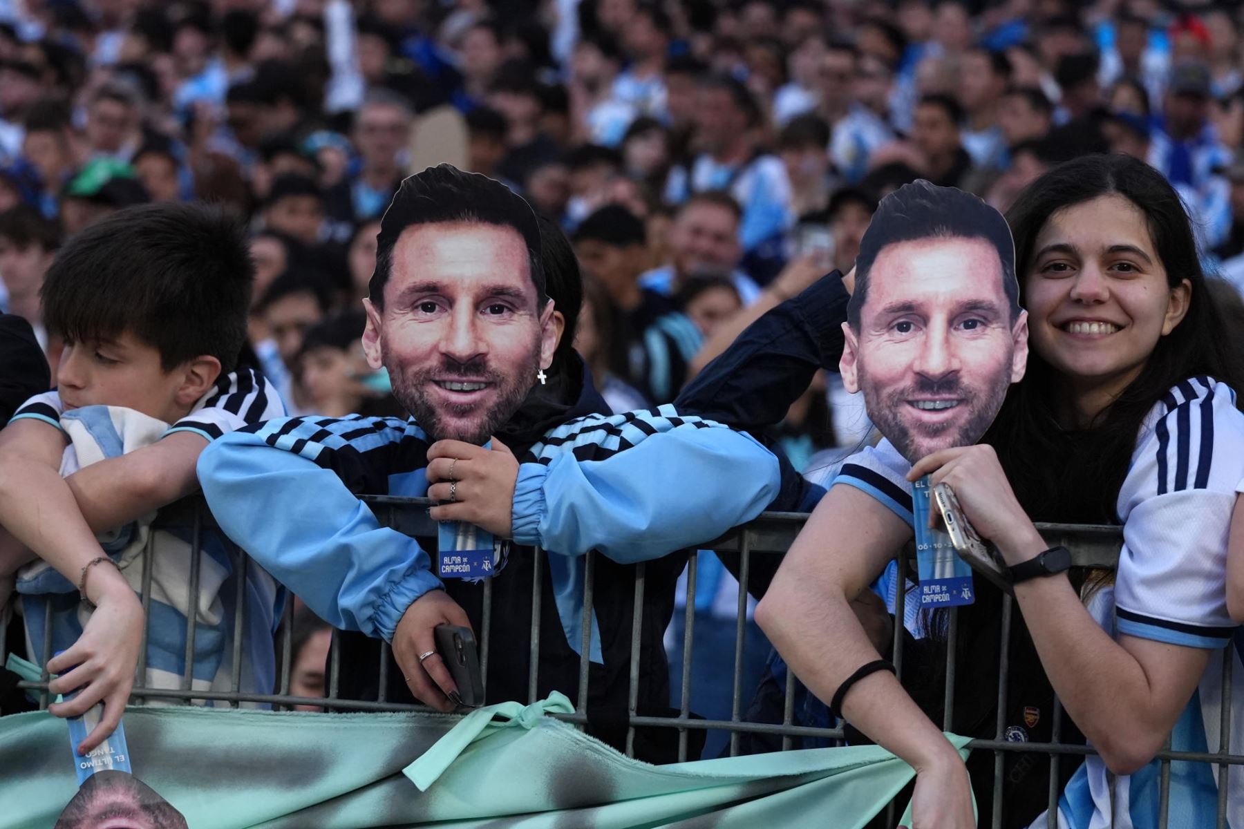 Aficionados de Argentina sostienen mascaras con la imagen de Lionel Messi este martes, previo a un partido amistoso internacional entre Argentina y Benín en el estadio Monumental, en Buenos Aires (Argentina). Parece la previa de una final de Mundial: bombos, banderas gigantes y miles de camisetas con el 10 en la espalda. Pero la marea albiceleste que llega al Monumental lo hace con una profunda tristeza, para presenciar un partido que nunca quiso ver: la despedida de Lionel Messi.  Foto: EFE