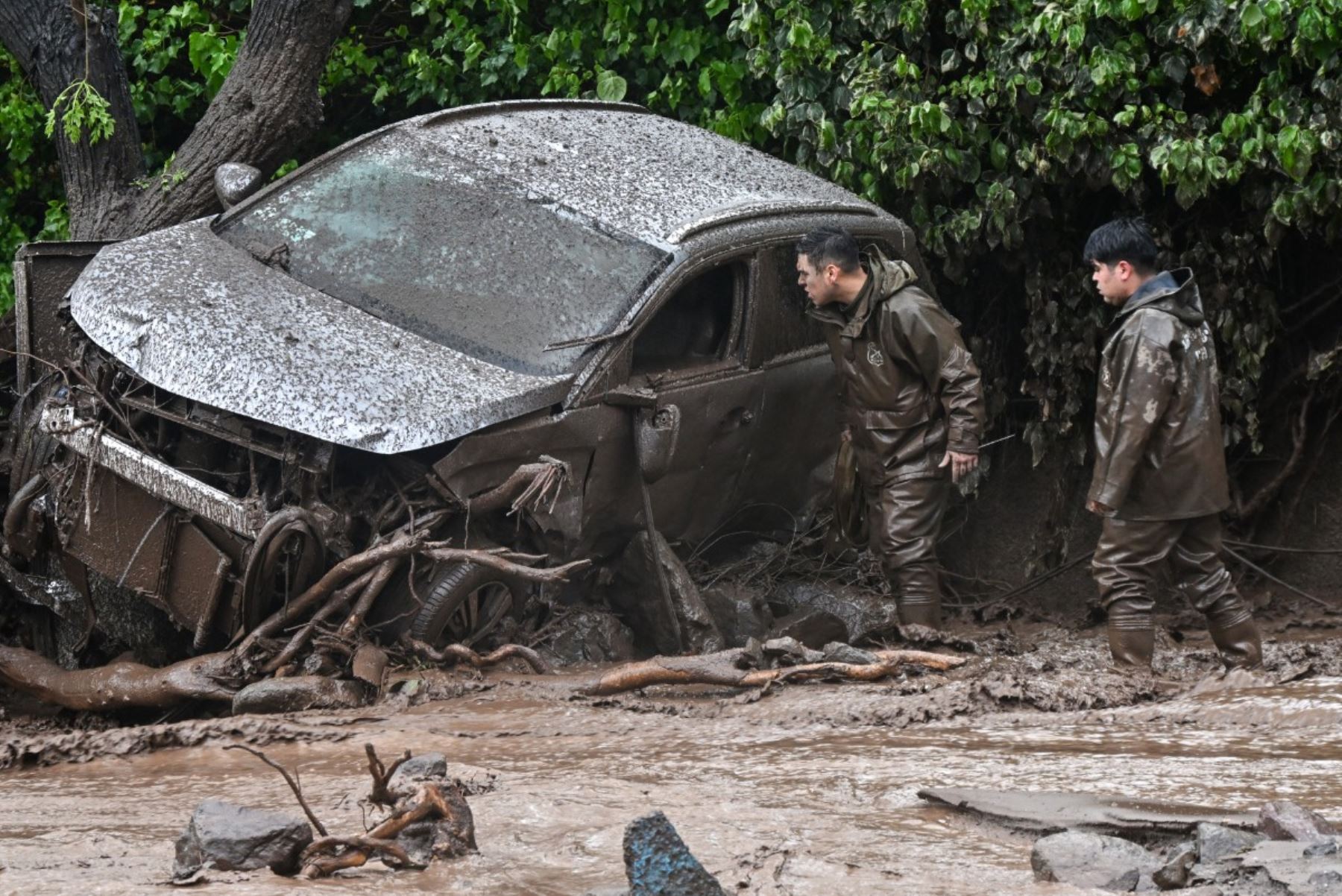 Vehículos quedaron cubiertos de lodo tras el paso del aluvión en Las Condes, una de las zonas afectadas por las intensas lluvias registradas en el sector oriente de Santiago. Foto: AFP