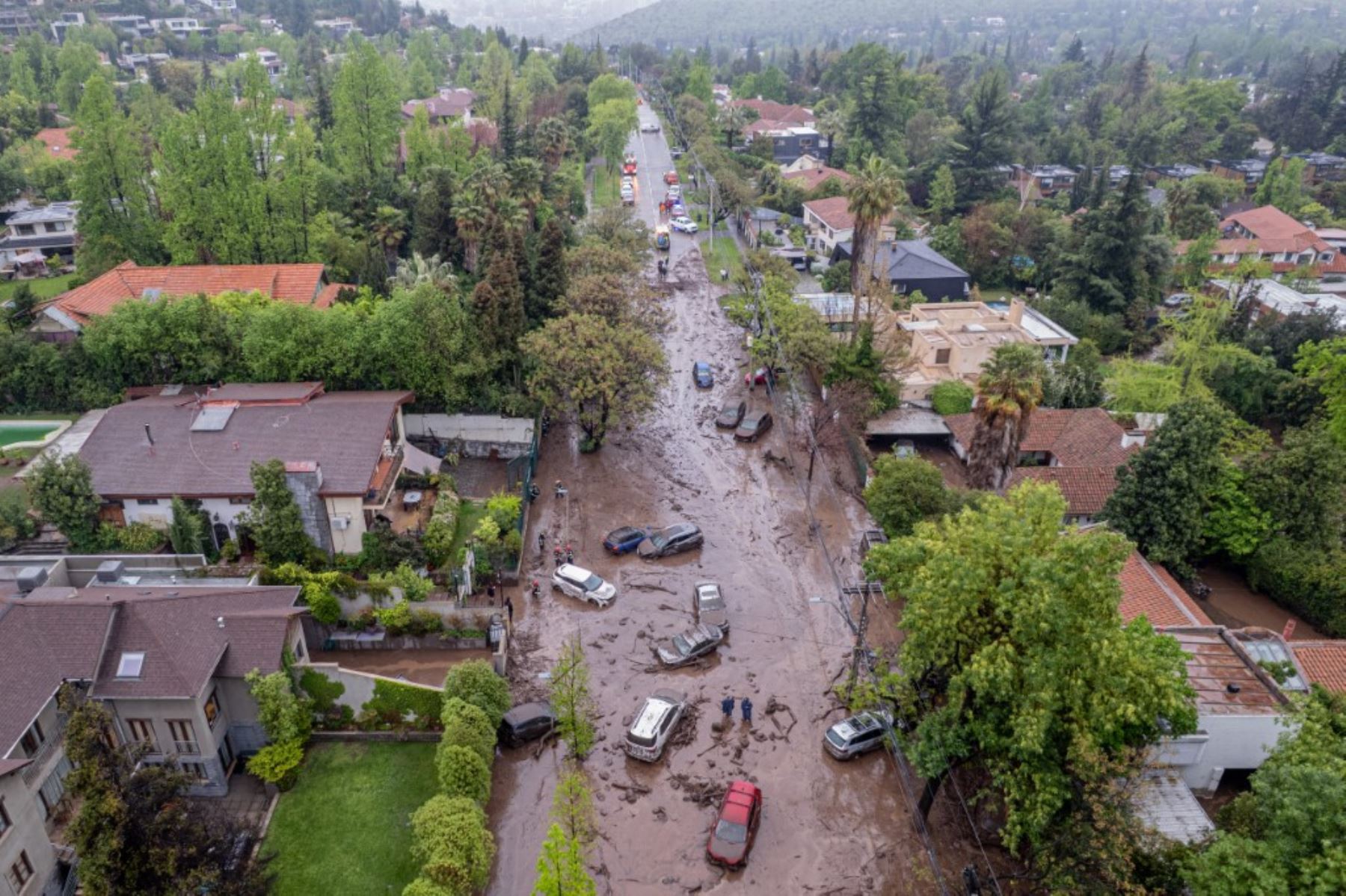 La emergencia afectó calles, viviendas y vehículos en el sector de San Carlos de Apoquindo, donde las lluvias activaron una quebrada y provocaron el arrastre de material. Foto: AFP