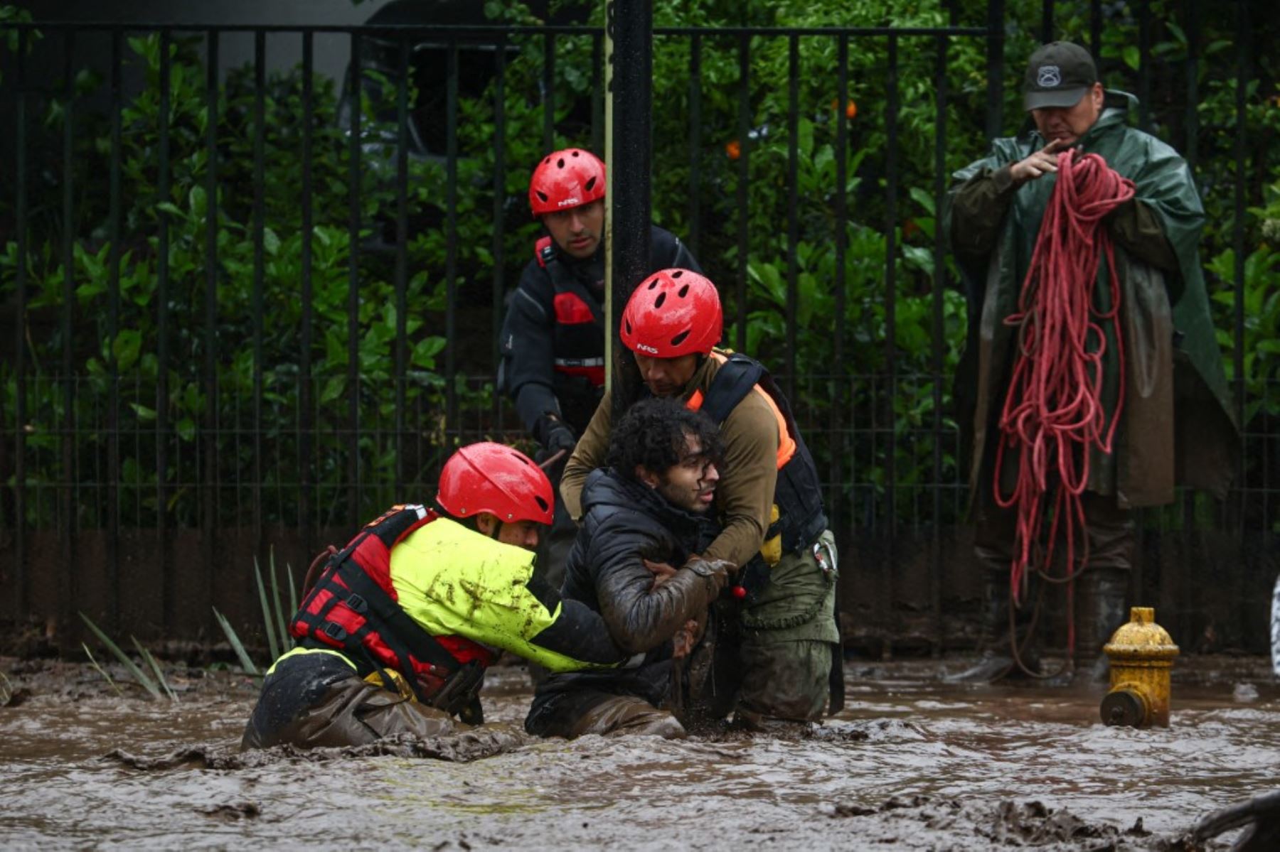 Equipos de emergencia trabajaron en las calles afectadas por el aluvión en San Carlos de Apoquindo, donde el barro y las piedras arrastraron vehículos y dejaron al menos seis personas lesionadas. Foto: AFP