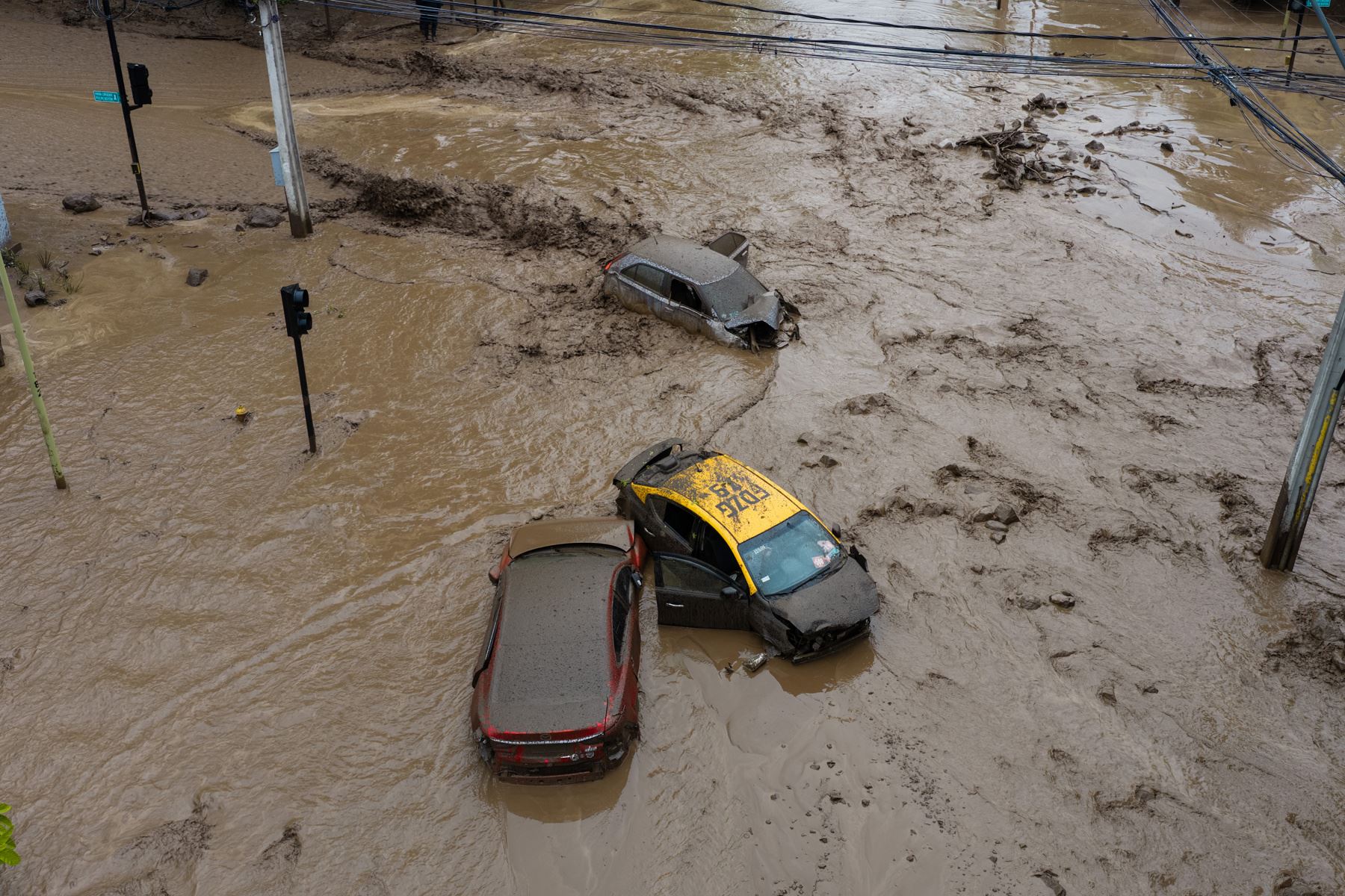 Vehículos afectados por un aluvión este jueves, en la comuna de Las Condes, en Santiago de Chile. Las autoridades chilenas informaron que, en medio de las fuertes lluvias que afectan la zona centro-sur del país, se produjo un aluvión en una zona precordillerana al este de Santiago, que arrastró vehículos y buses. Foto: EFE