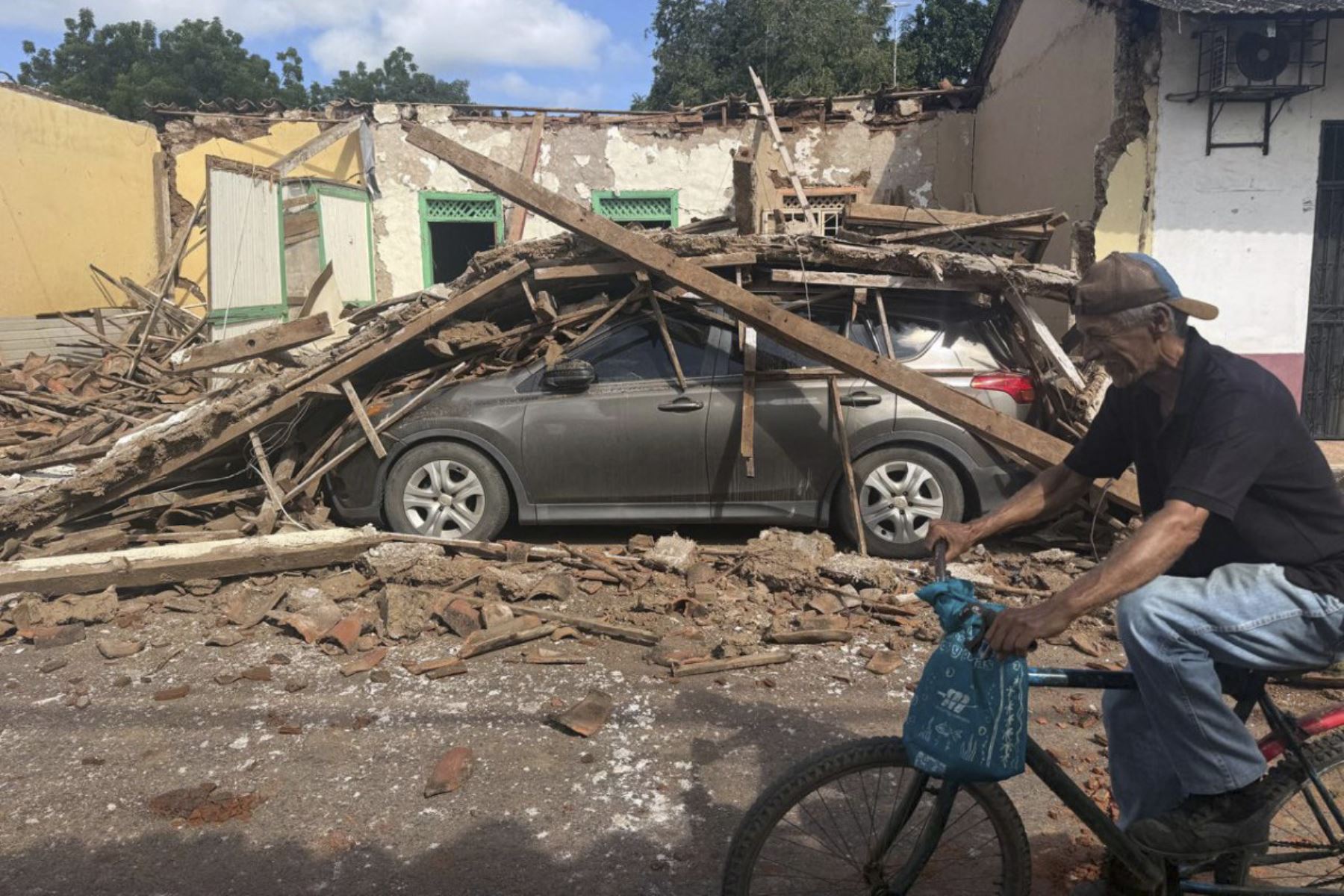 Un hombre pasa en bicicleta frente a una casa derrumbada y un auto sepultado bajo los escombros en la ciudad de Chitré, a unos 250 km al suroeste de Ciudad de Panamá, el 10 de octubre de 2026.
Un poderoso terremoto de magnitud 7,7 sacudió Panamá el 10 de octubre de 2026, derrumbando edificios y carreteras en el centro del país y dejando al menos 27 personas heridas, sin que se hayan reportado muertos.
 Foto: AFP