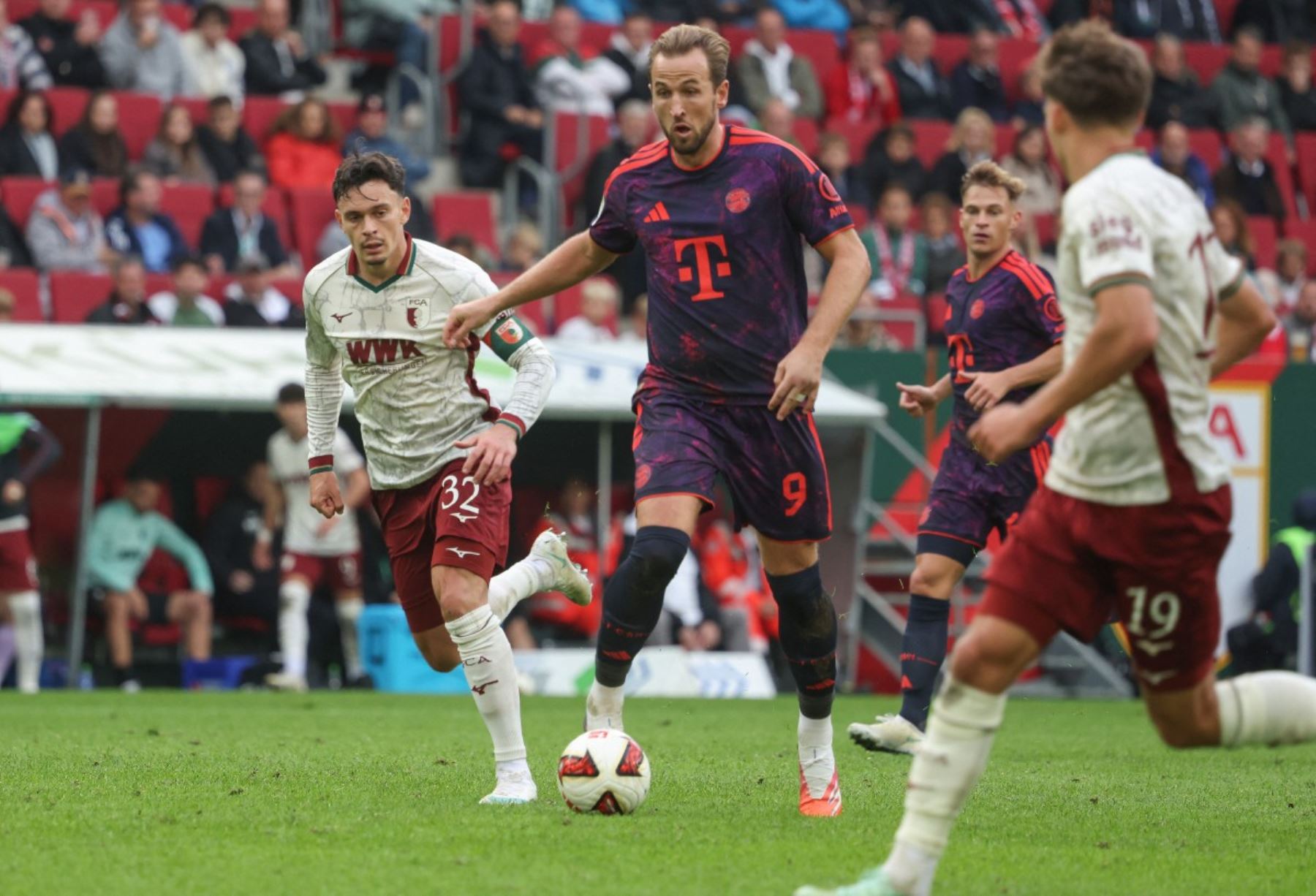 El delantero inglés del Bayern de Múnich, Harry Kane (n.º 9, centro), y el centrocampista suizo del Augsburgo, Fabian Rieder (n.º 32, izquierda), pugnan por el balón durante el partido de la Bundesliga (primera división alemana) entre el FC Augsburgo y el FC Bayern de Múnich, disputado en Augsburgo  Foto: AFP