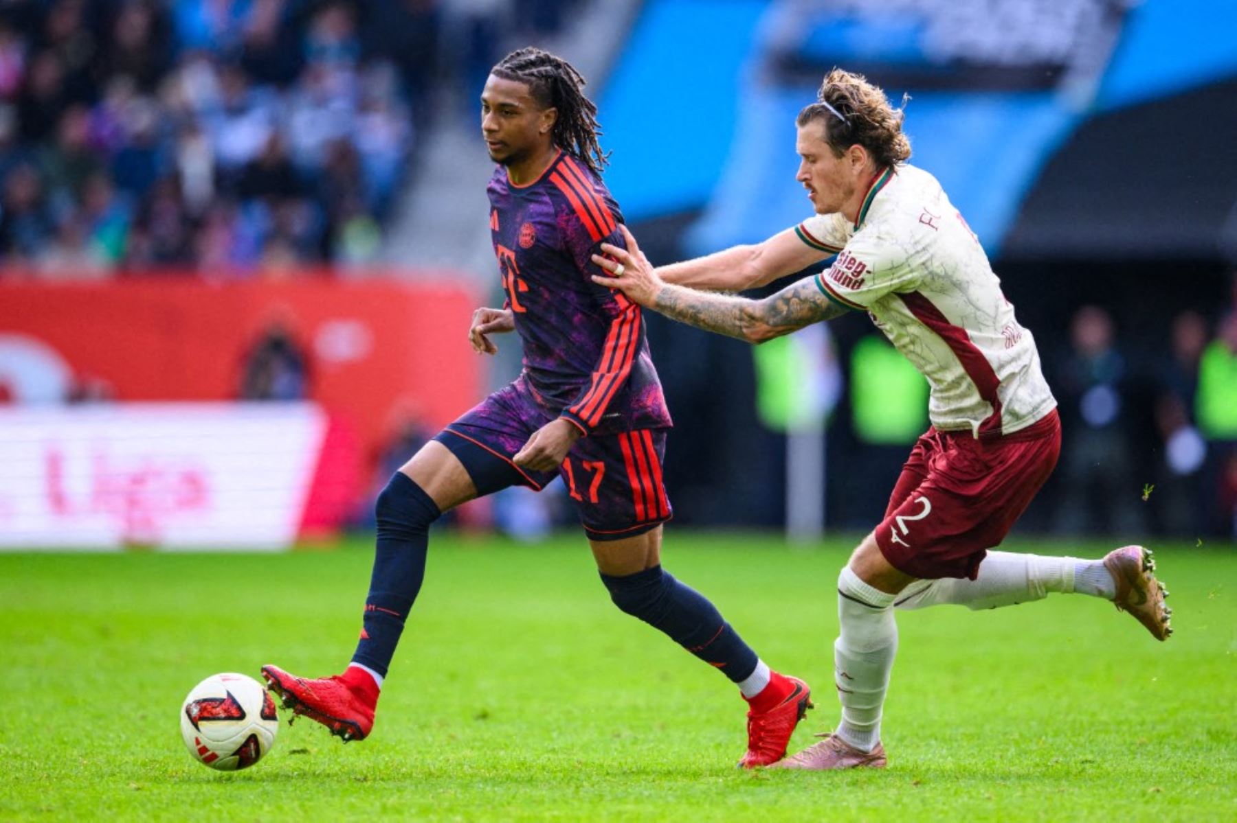 Bundesliga, FC Augsburg contra Bayern de Múnich, jornada 5, WWK-Arena. Michael Olise (Bayern de Múnich) en acción frente a Calvin Brackelmann (FC Augsburg). Foto: AFP