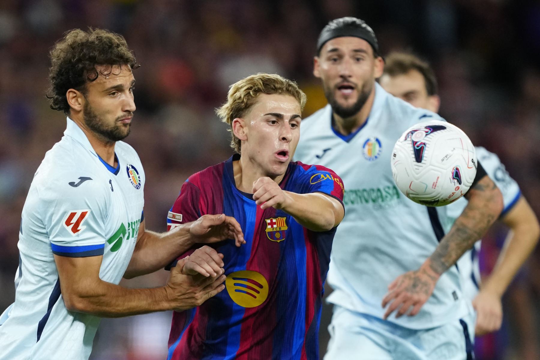 El centrocampista del Barcelona Fermín López (c) pelea un balón con Sebastián Boselli (i), del Getafe, durante el partido de LaLiga EA Sports que FC Barcelona y Getafe CF disputan este sábado en el Camp Nou.  Foto: EFE