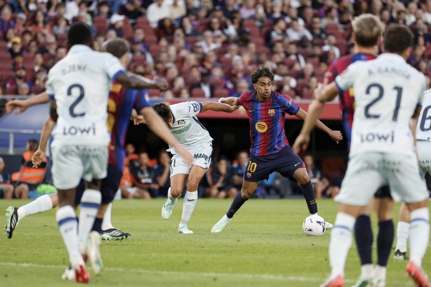 El futbolista del FC Barcelona Lamine Yamal c-d) se enfrenta a Ramón Terrats (c-i), del Getafe CF, durante su partido de la jornada 8 de LaLiga EA Sports en el Camp Nou este sábado en Barcelona. Foto: EFE
