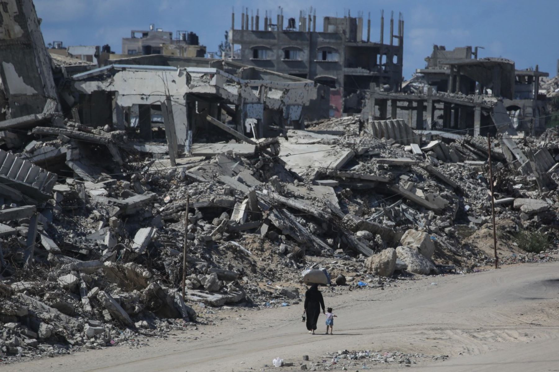 Unos palestinos caminan por una calle flanqueada por edificios destruidos en el campo de refugiados de Jabalia, en el norte de la Franja de Gaza, el 5 de octubre de 2026. AFP