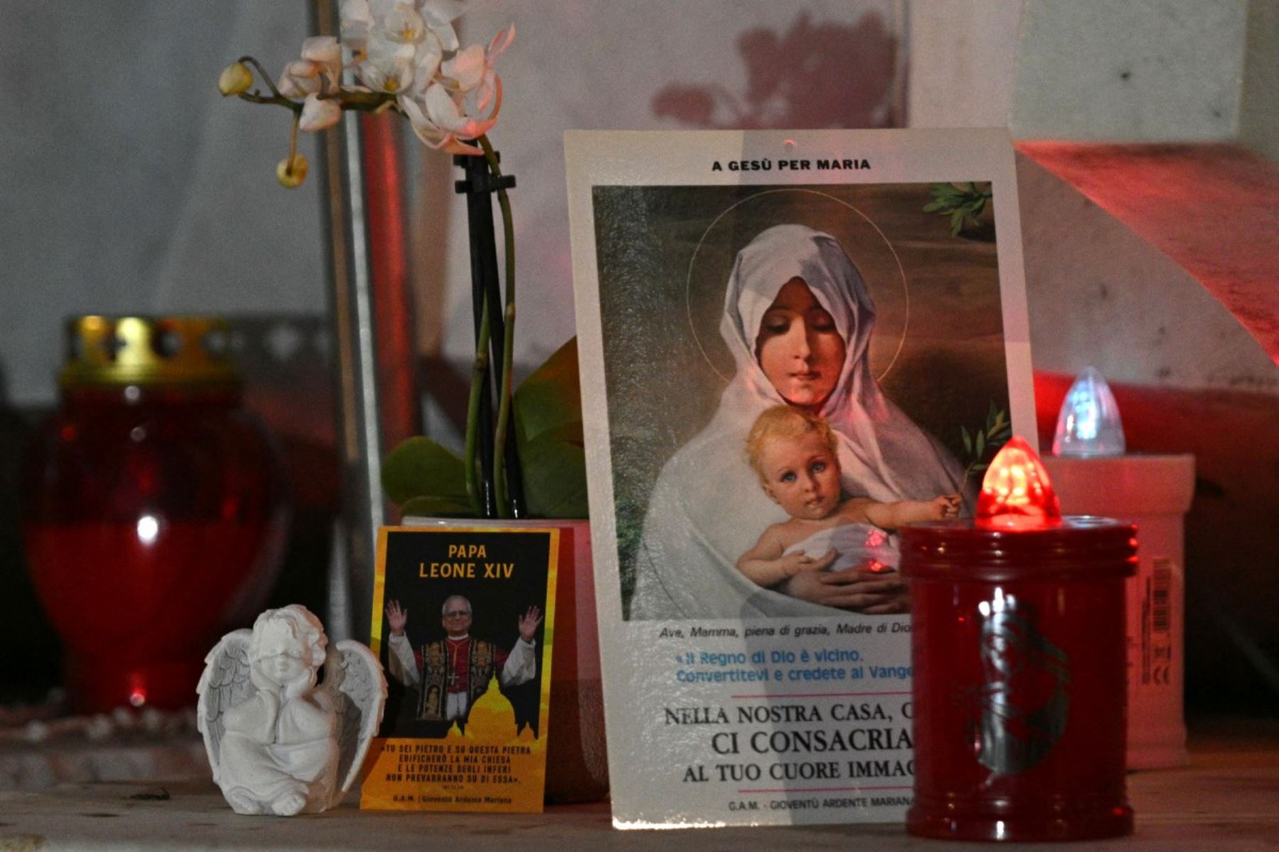 Se encienden velas, se depositan flores y se elevan oraciones ante la estatua de Juan Pablo II, situada frente al Hospital Universitario Gemelli de Roma, donde el papa León XIV ha sido ingresado para someterse a una operación destinada a extirpar un nódulo pulmonar. Foto: AFP