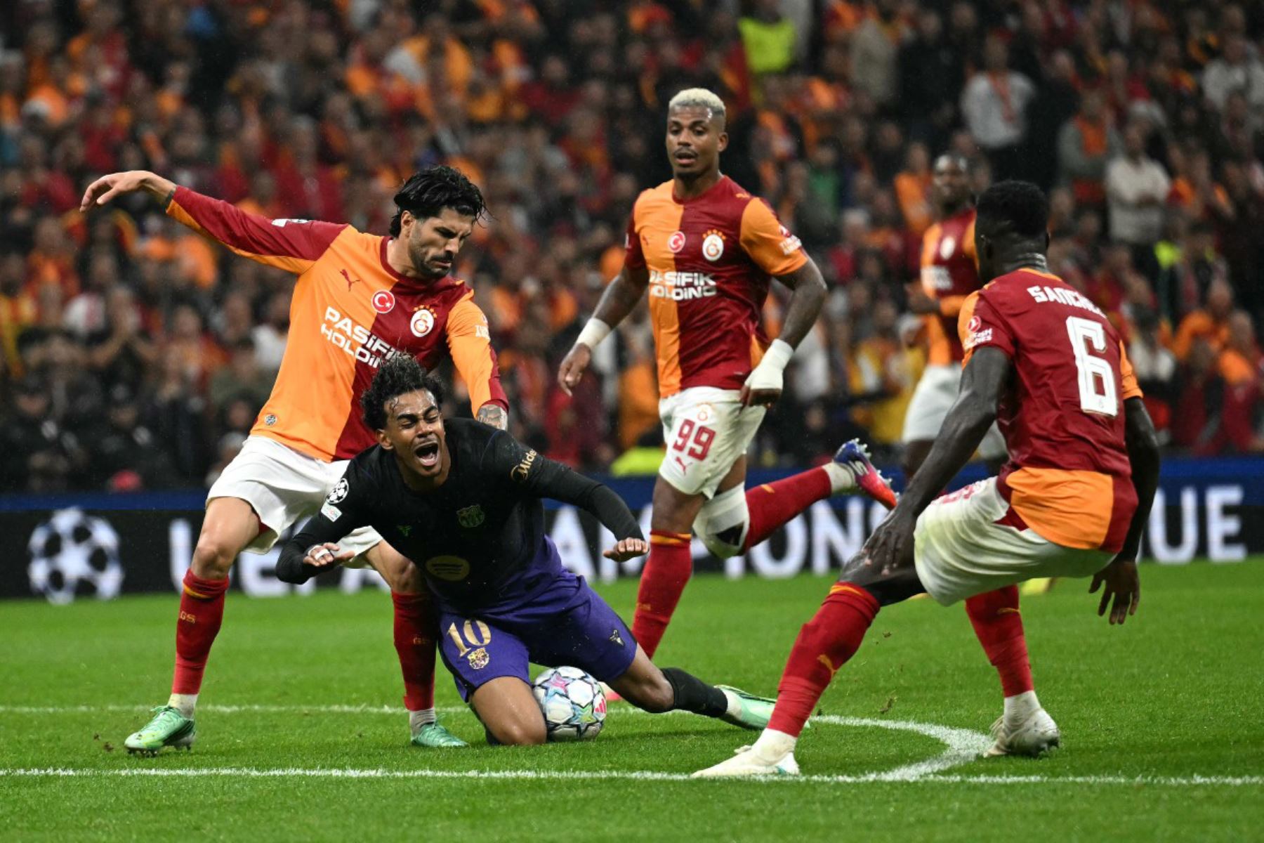 El delantero español del Barcelona, ​​Lamine Yamal , cae al suelo tras una disputa con el defensa turco del Galatasaray, durante el partido de fútbol de la segunda jornada de la fase de liga de la UEFA Champions League entre el Galatasaray y el Barcelona. Foto: AFP