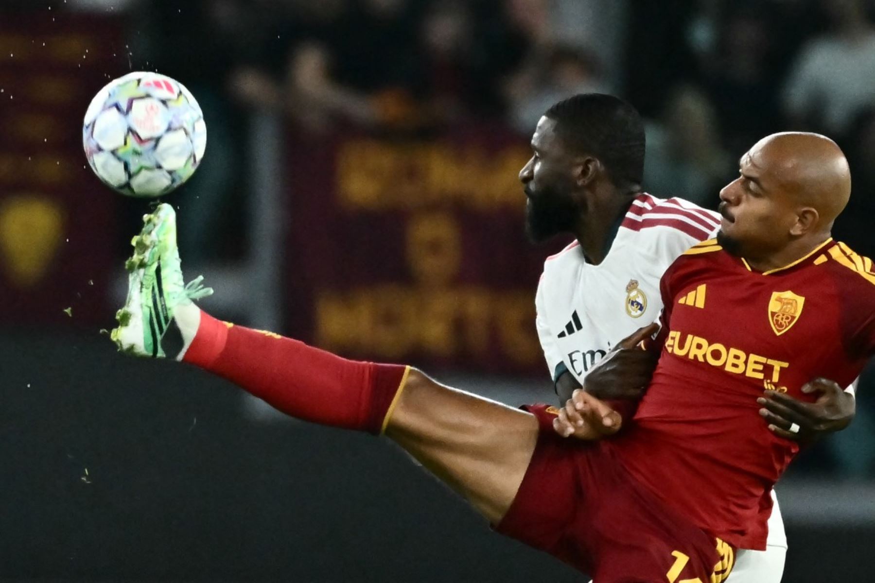 El delantero neerlandés de la AS Roma, Donyell Malen (n.º 14), disputa el balón con el defensa alemán del Real Madrid, Antonio Rüdiger (n.º 22), durante el partido de la segunda jornada de la primera fase de la Liga de Campeones de la UEFA entre la AS Roma y el Real Madrid, celebrado en el Estadio Olímpico de Roma  Foto: ANDINA/Difusión