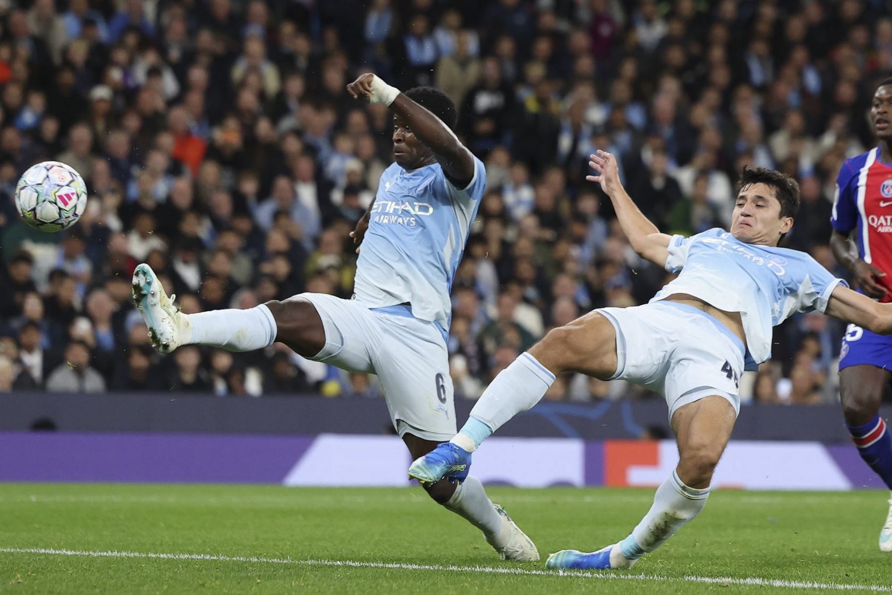 Marc Guehi (izq.) y Abdukodir Khusanov (centro), del Manchester City, en acción durante el partido de la Liga de Campeones de la UEFA entre el Manchester City y el Paris Saint-Germain  Foto: EFE