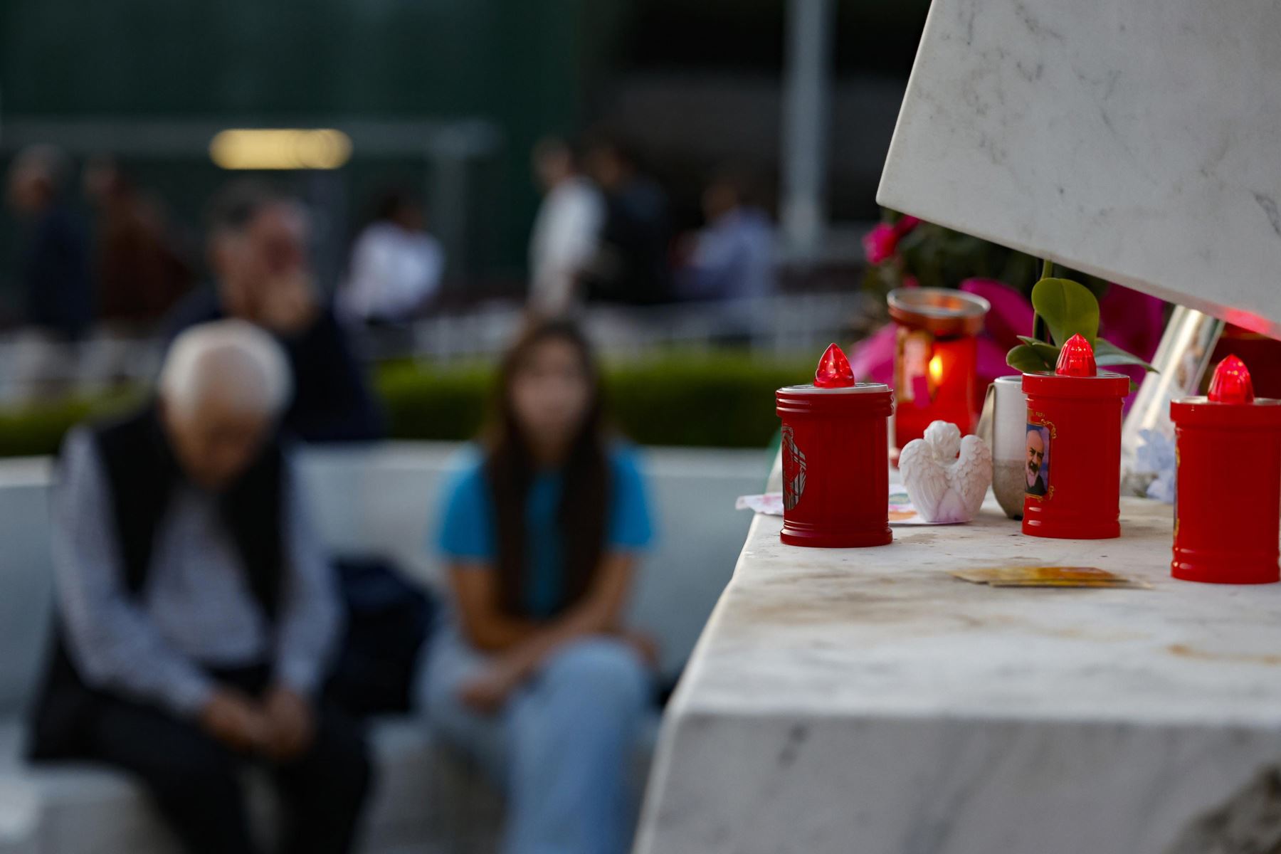 Personas rezan ante la estatua del papa Juan Pablo II frente al Hospital Universitario Agostino Gemelli, donde se encuentra ingresado el papa León XIV, en Roma, Italia. Foto: EFE