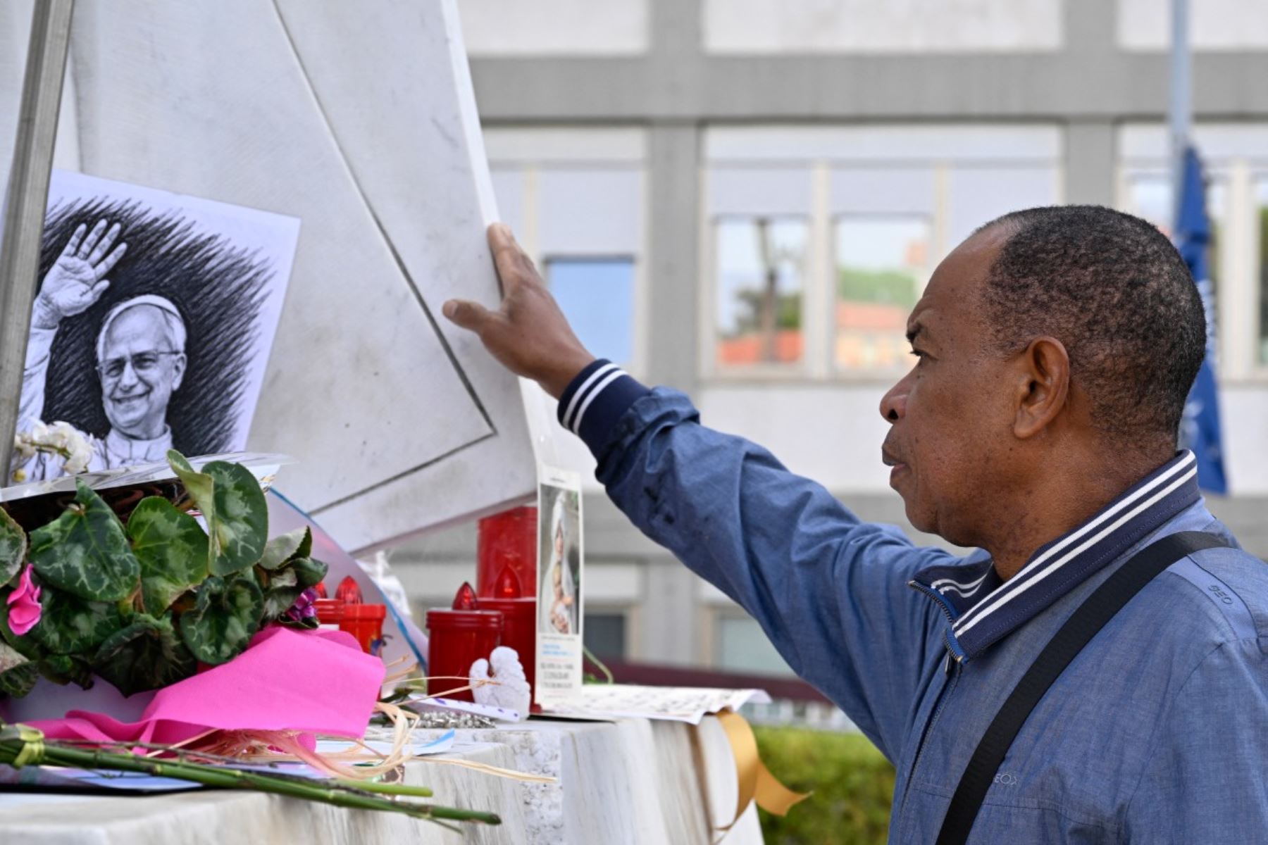 Un dibujo del papa León XIV se encuentra depositado junto a la estatua de Juan Pablo II, en el exterior del Hospital Universitario Gemelli, en Roma, donde el papa León XIV se recupera tras haber sido sometido a una intervención quirúrgica para extirpar un tumor canceroso de su pulmón derecho. AFP