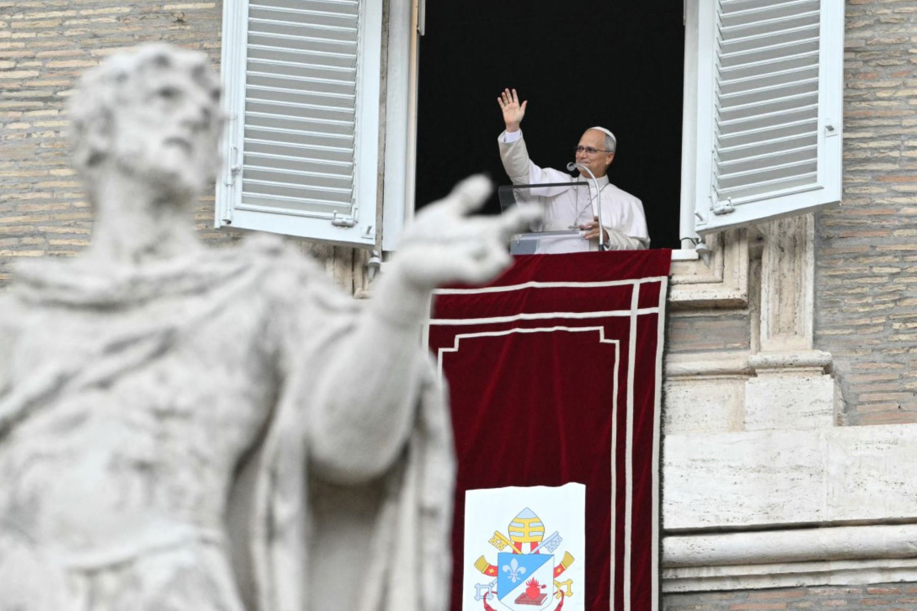 El Papa León XIV agradece a la multitud desde la ventana del palacio apostólico que da a la plaza de San Pedro, durante el rezo del Ángelus, un día después de su regreso al Vaticano tras una intervención quirúrgica para extirpar un tumor canceroso en su pulmón derecho, el 18 de octubre de 2026. Foto: AFP
