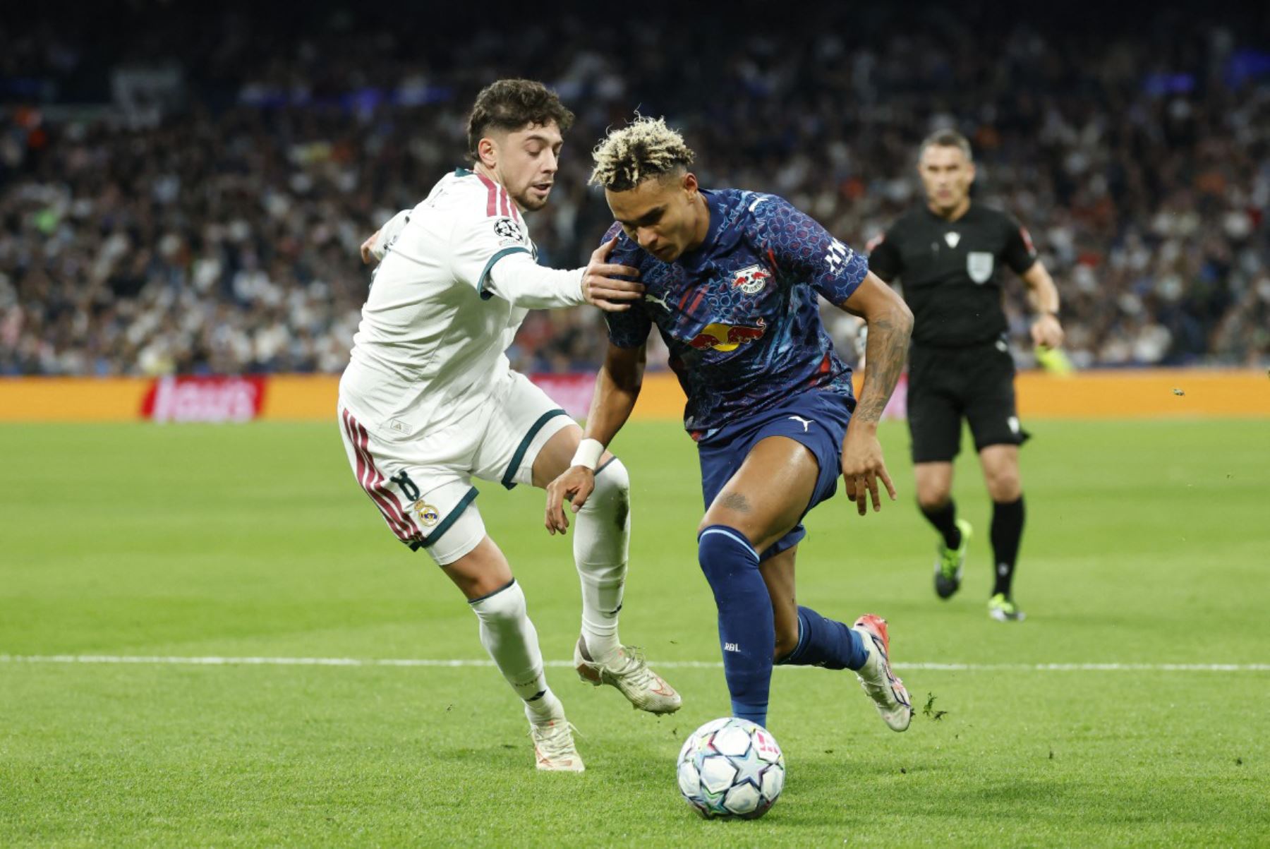 El delantero noruego del RB Leipzig, Antonio Nusa, es disputado por el centrocampista uruguayo del Real Madrid, Federico Valverde, durante el partido de la tercera jornada de la primera fase de la Liga de Campeones de la UEFA entre el Real Madrid CF y el RB Leipzig. 
Foto: ANDINA/AFP