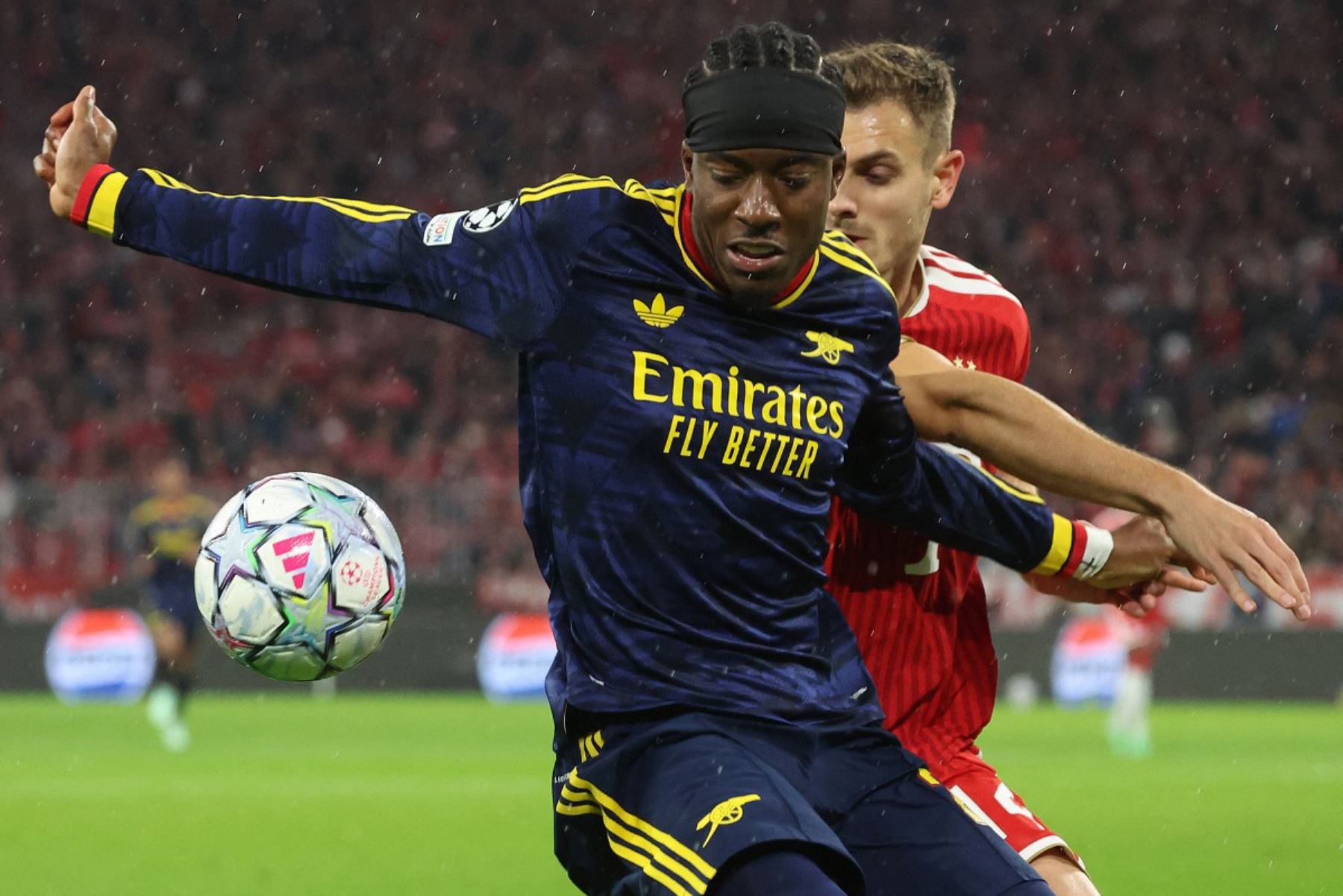 El centrocampista inglés del Arsenal, Noni Madueke, y el defensa croata del Bayern de Múnich, Josip Stanisic, disputan el balón durante el partido de la Liga de Campeones de la UEFA entre el FC Bayern de Múnich y el Arsenal FC, celebrado en Múnich, en el sur de Alemania. Foto: ANDINA/AFP