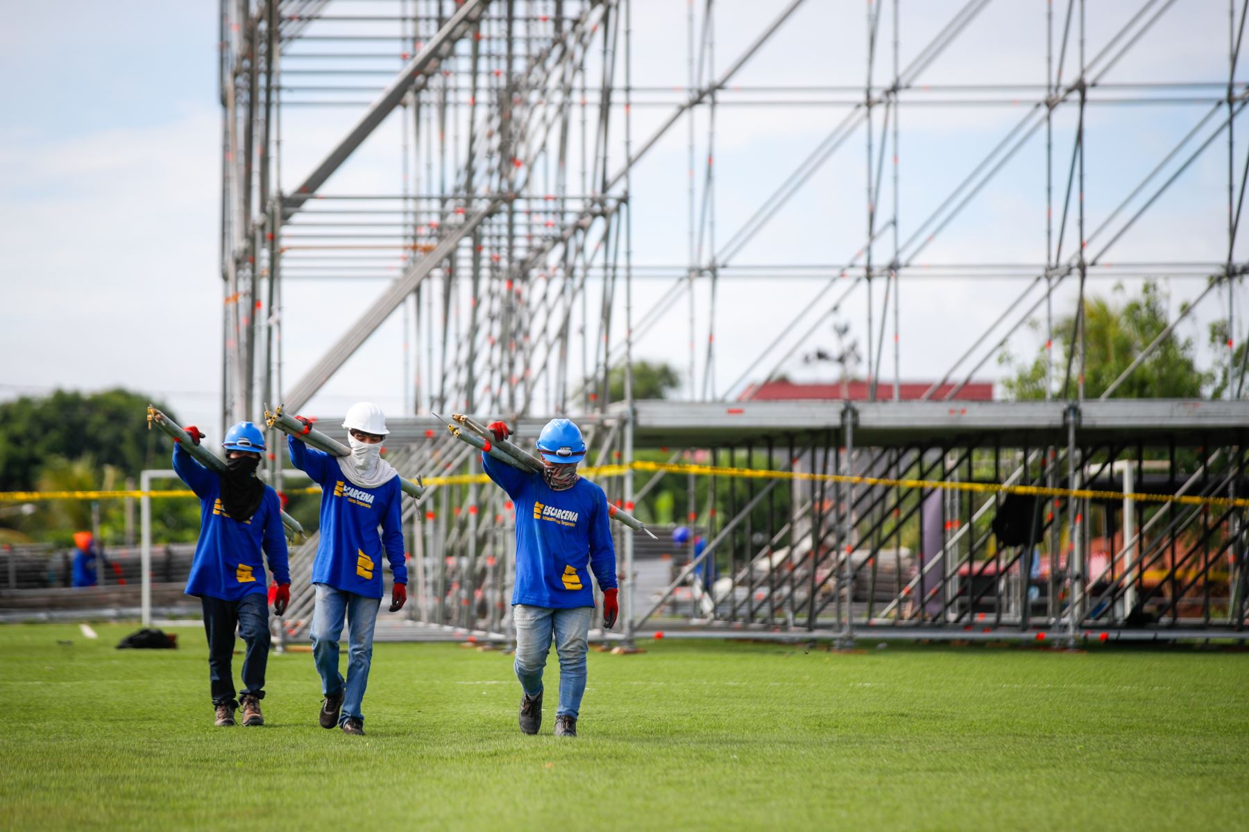 Operarios trasladan pesados tubos de acero que serán utilizados en el montaje de las torres de iluminación y sonido para el escenario principal en el complejo deportivo La Videnita, en Pucallpa, donde se celebrará la misa del papa León XIV. Foto: ANDINA/Ricardo Cuba