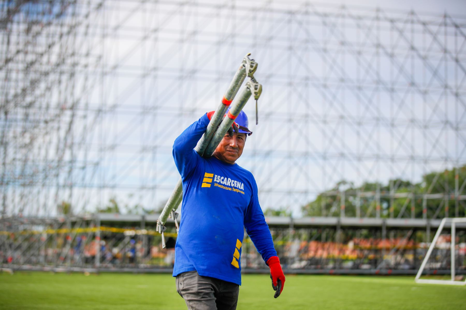 Operarios trasladan pesados tubos de acero que serán utilizados en el montaje de las torres de iluminación y sonido para el escenario principal en el complejo deportivo La Videnita, en Pucallpa, donde se celebrará la misa del papa León XIV. Foto: ANDINA/Ricardo Cuba