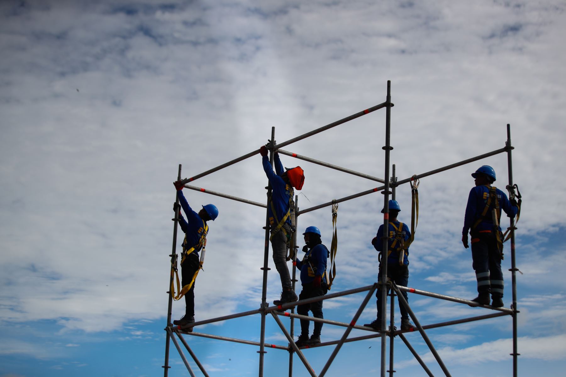 Obreros realizan trabajos en altura durante el montaje de las estructuras metálicas que sostendrán el escenario principal en el complejo deportivo La Videnita, en Pucallpa, donde se celebrará la misa del papa León XIV. Foto: ANDINA/Ricardo Cuba