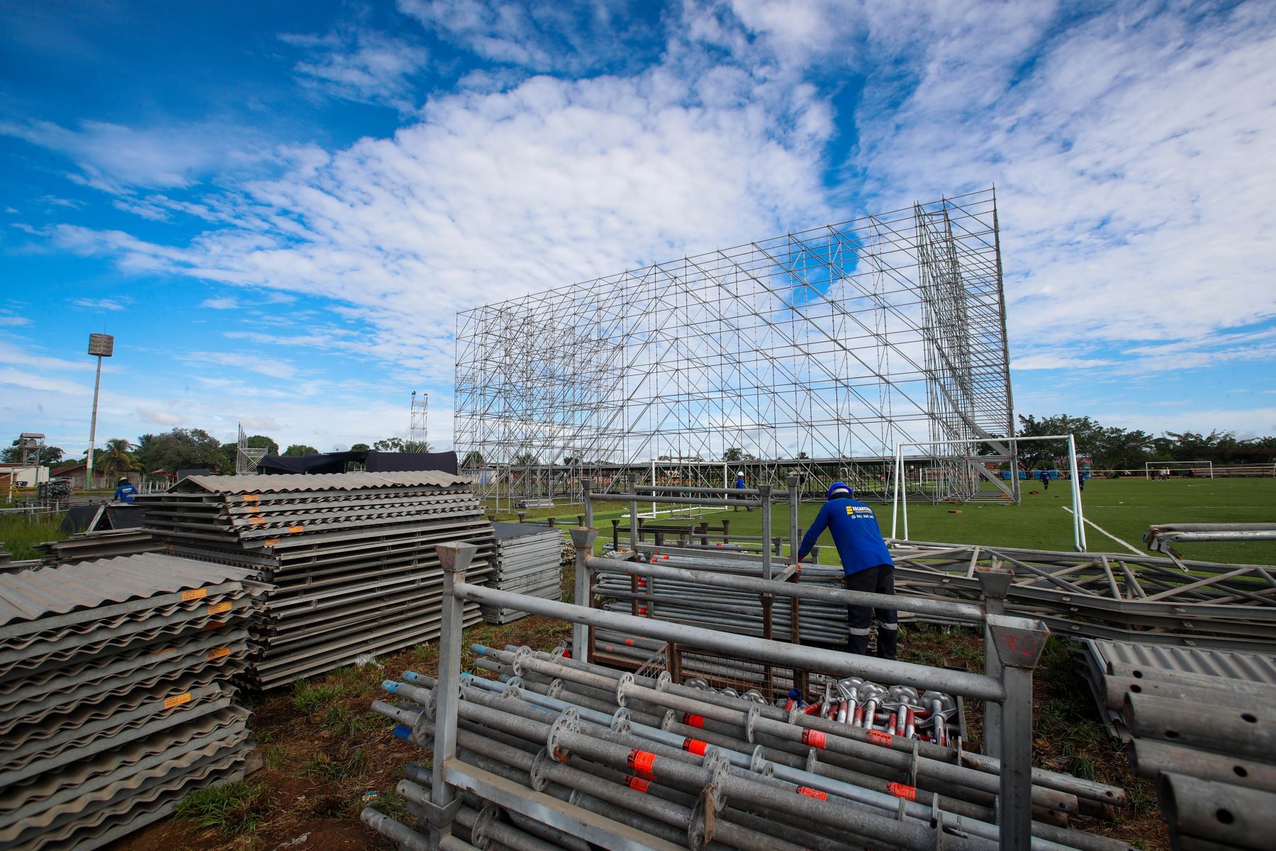 Operarios trasladan pesados tubos de acero que serán utilizados en el montaje de las torres de iluminación y sonido para el escenario principal en el complejo deportivo La Videnita, en Pucallpa, donde se celebrará la misa del papa León XIV. Foto: ANDINA/Ricardo Cuba