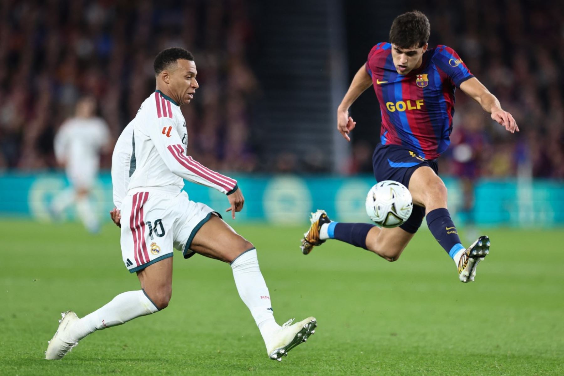El delantero francés del Real Madrid, Kylian Mbappé disputa un balón con el defensa español del Barcelona, ​​Pau Cubarsí  durante el partido de la liga española de fútbol entre el FC Barcelona y el Real Madrid. AFP