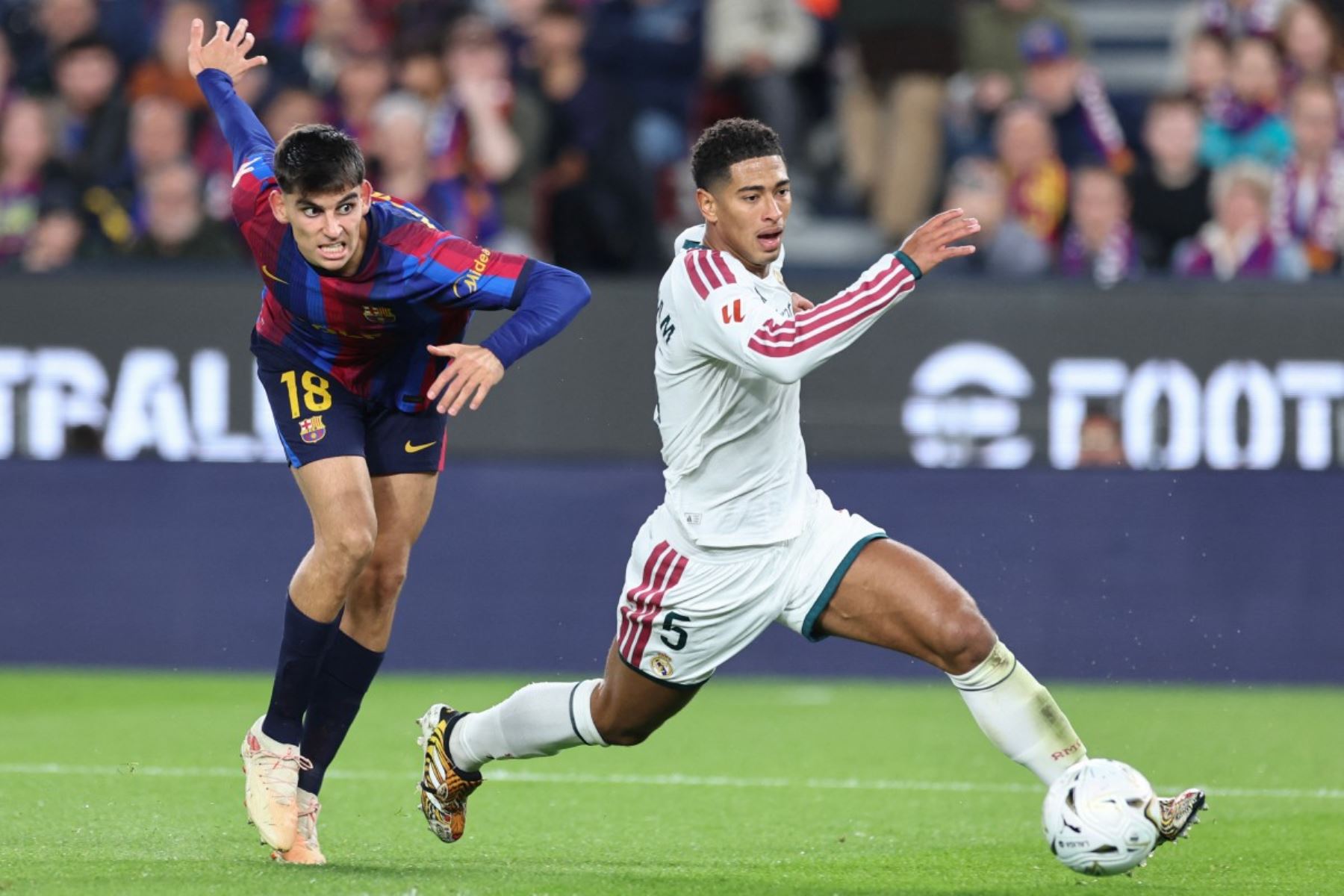 El centrocampista inglés del Real Madrid, Jude Bellingham  supera al defensa español del FC Barcelona, ​​Gerard Martín  durante el partido de la liga española de fútbol entre el FC Barcelona y el Real Madrid. AFP