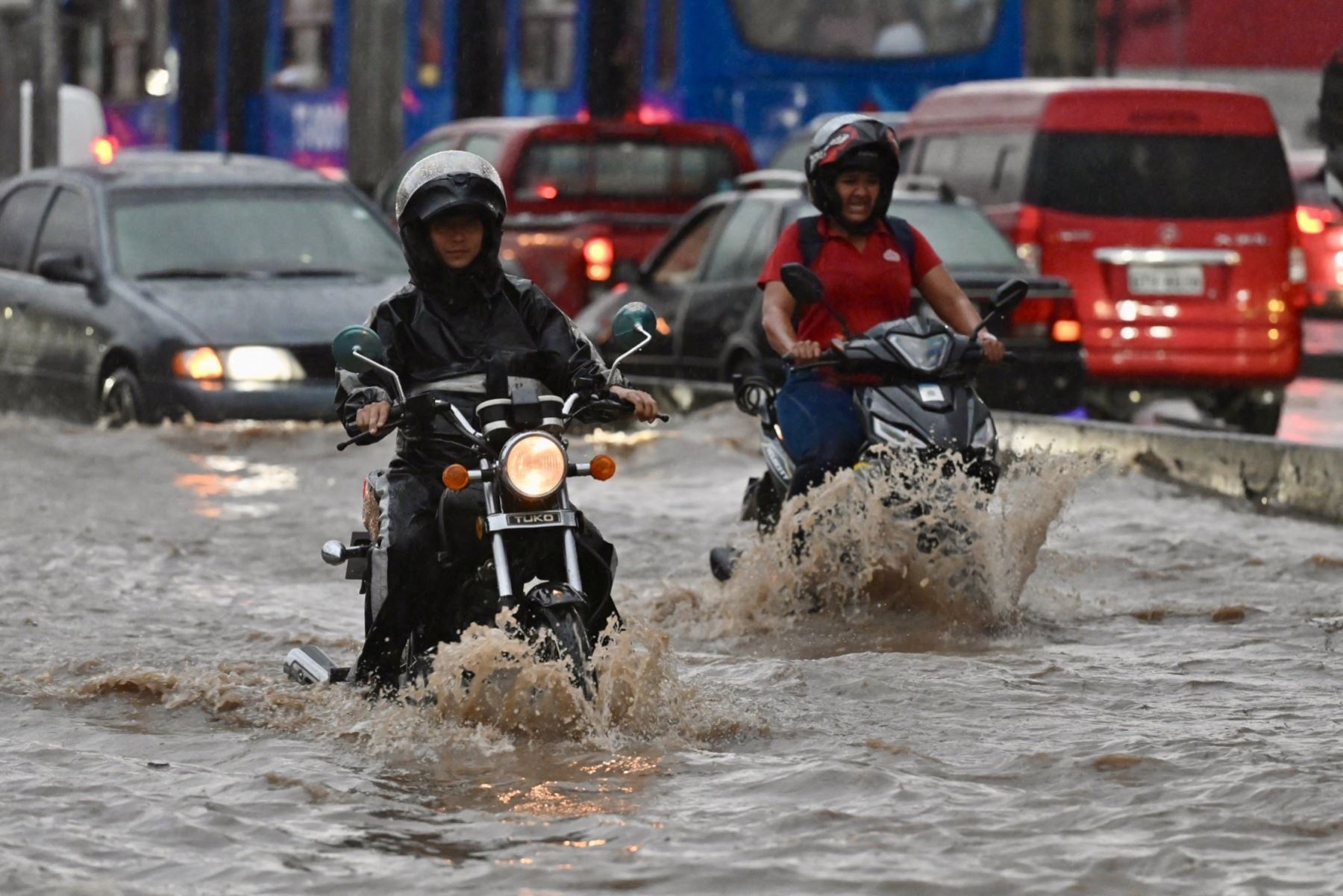 Motocicletas se abren paso a través de aguas anegadas tras fuertes lluvias en el norte de Guayaquil, Ecuador. AFP
