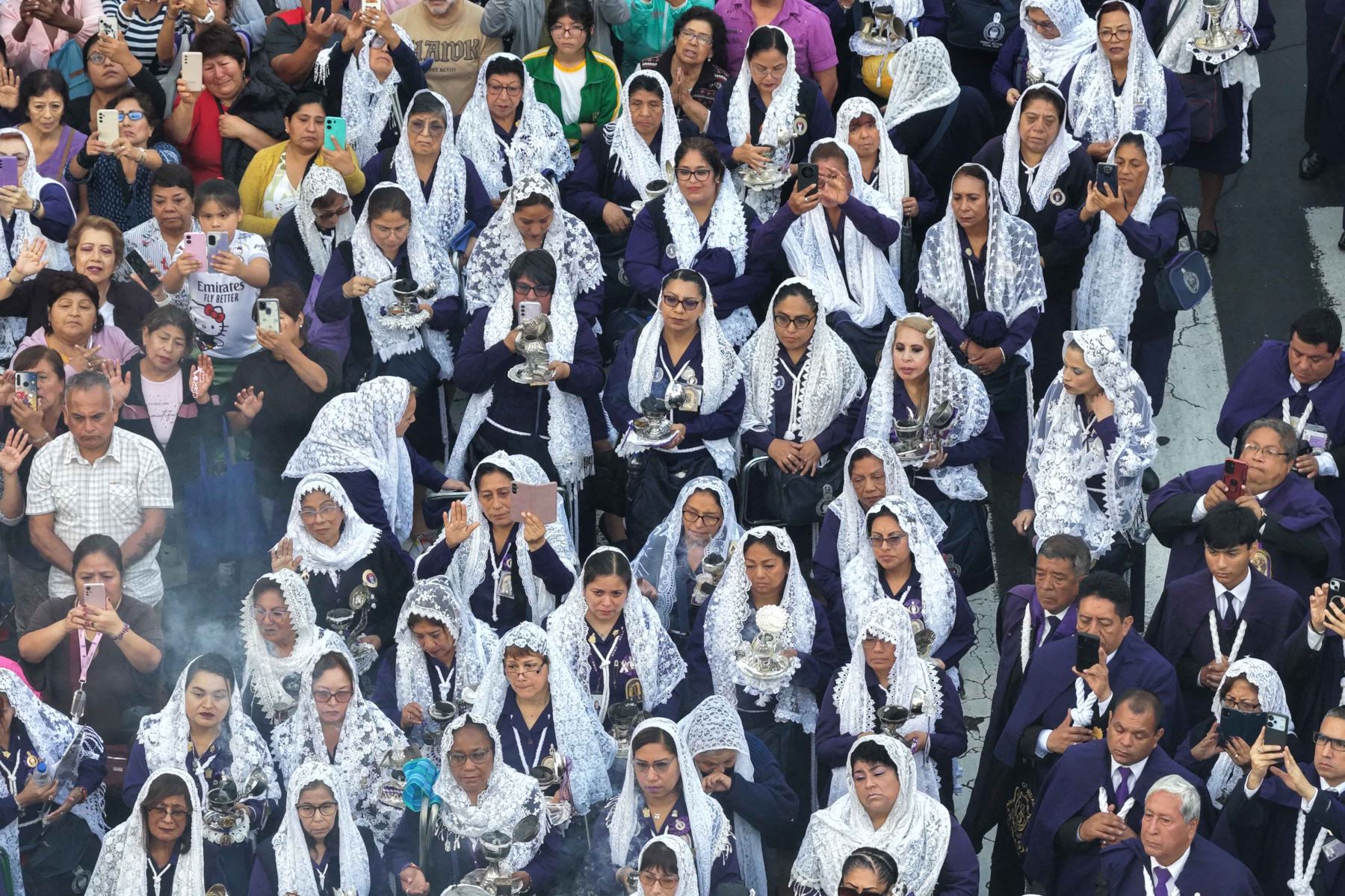 Un grupo de mujeres con mantillas blancas participa en la procesión del Señor de los Milagros. La celebración reúne a diferentes agrupaciones religiosas y devotos que acompañan el recorrido del Cristo Moreno por Lima. Foto: ANDINA/Daniel Bracamonte.