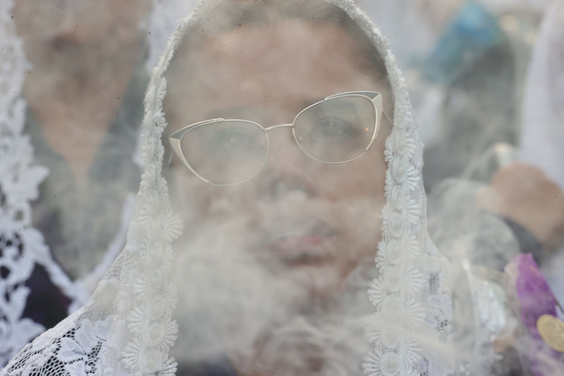 El humo del incienso rodea a una devota durante la procesión del Señor de los Milagros en Lima. Los sahumerios forman parte de las manifestaciones religiosas que acompañan el desplazamiento de las andas del Cristo Moreno por las calles de la capital. Foto: ANDINA/Carlos Lezama.