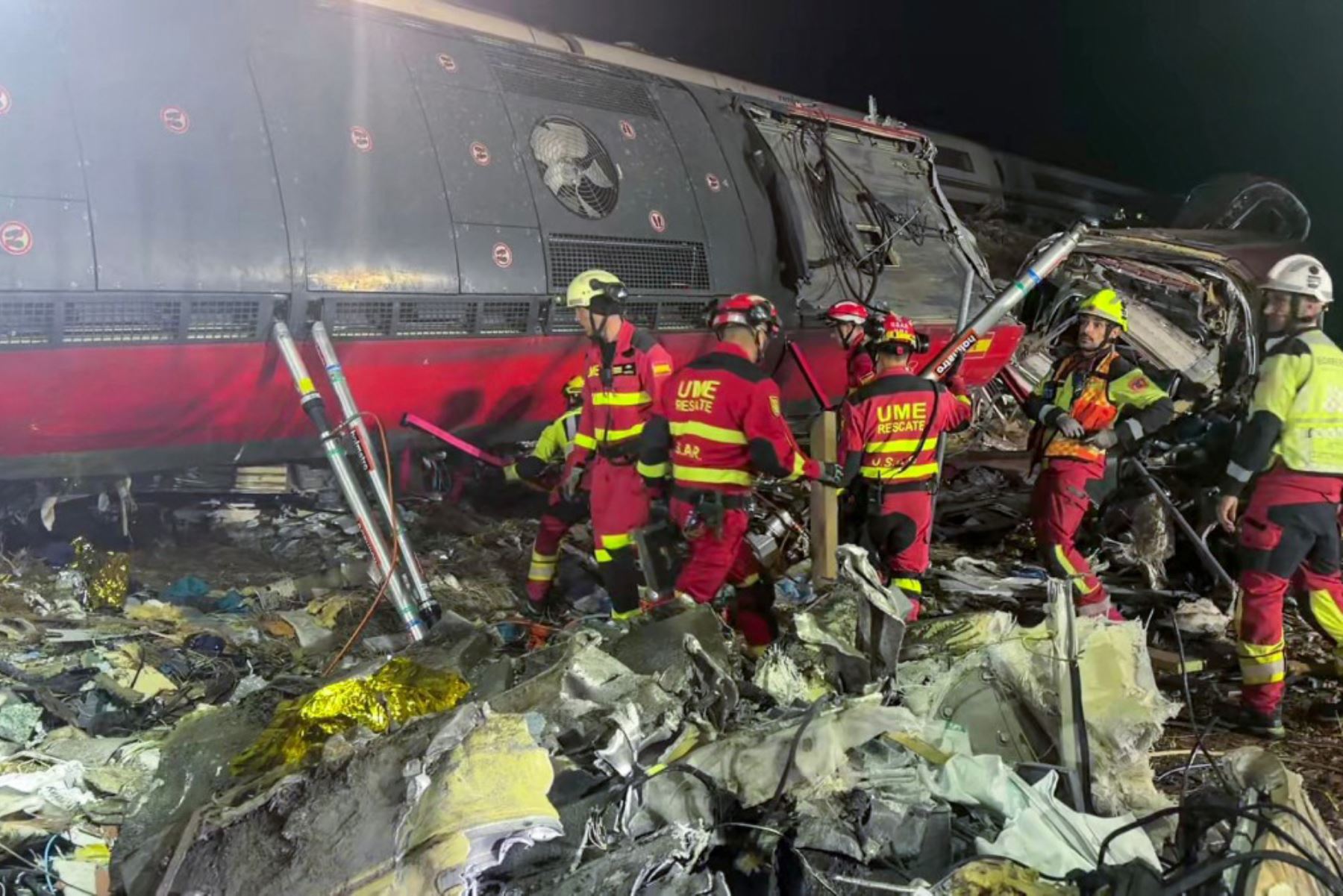 Miembros de la Unidad Militar de Emergencias (UME) retiran escombros para utilizar grúas pesadas y extraer los vagones dañados de un accidente ferroviario entre dos trenes de alta velocidad, un Renfe AVE y un Iryo, ocurrido el 28 de octubre de 2026 a unos 150 km al sur de Madrid, entre Urda y Los Yebenes, en la provincia de Toledo. Foto: AFP