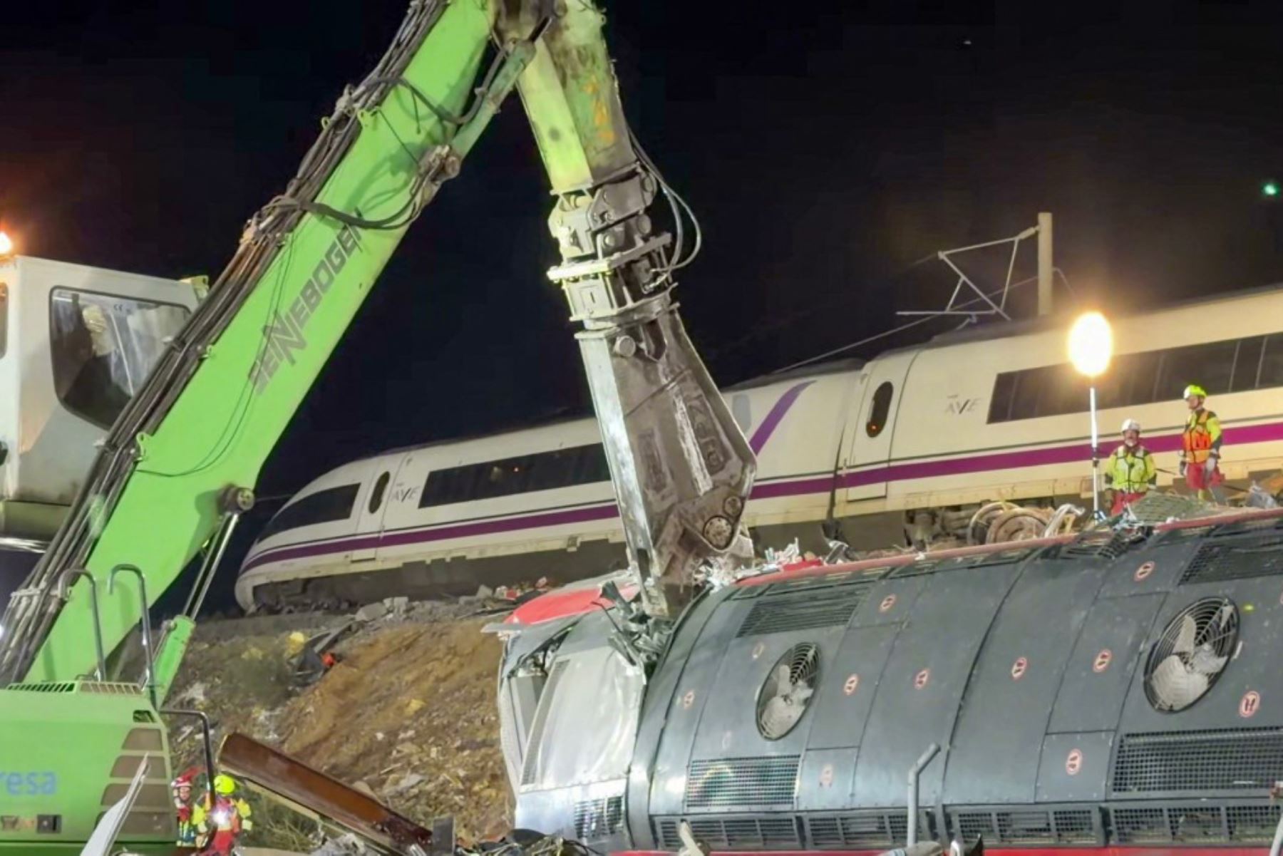 Equipos de emergencia realizan labores de rescate entre los restos de los trenes accidentados en España. Foto: AFP