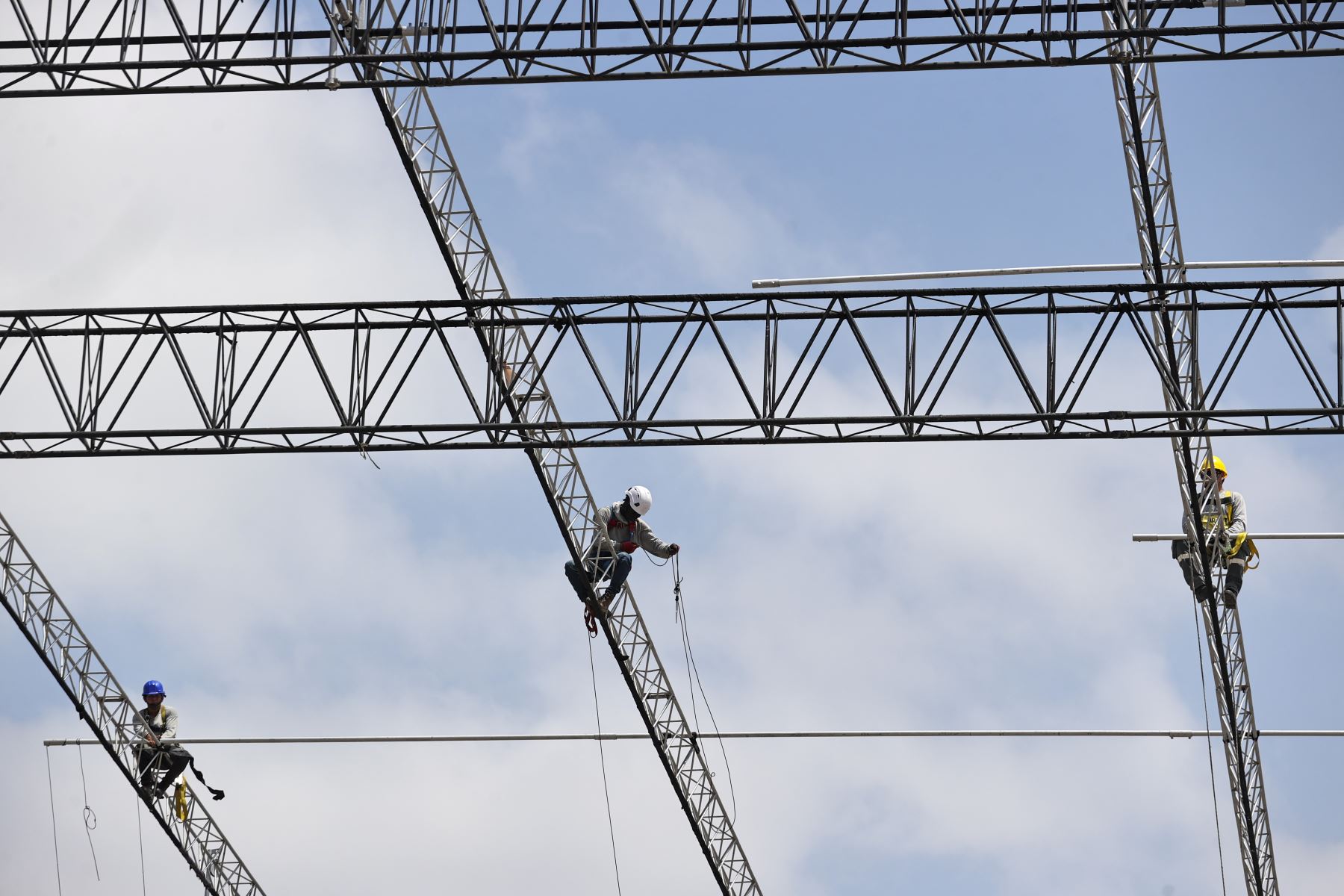 Operarios realizan labores en altura sobre las estructuras metálicas instaladas en la Base Aérea Las Palmas como parte de los preparativos para la misa que congregará a miles de fieles en Lima. Foto: ANDINA/Juan Carlos Guzmán.